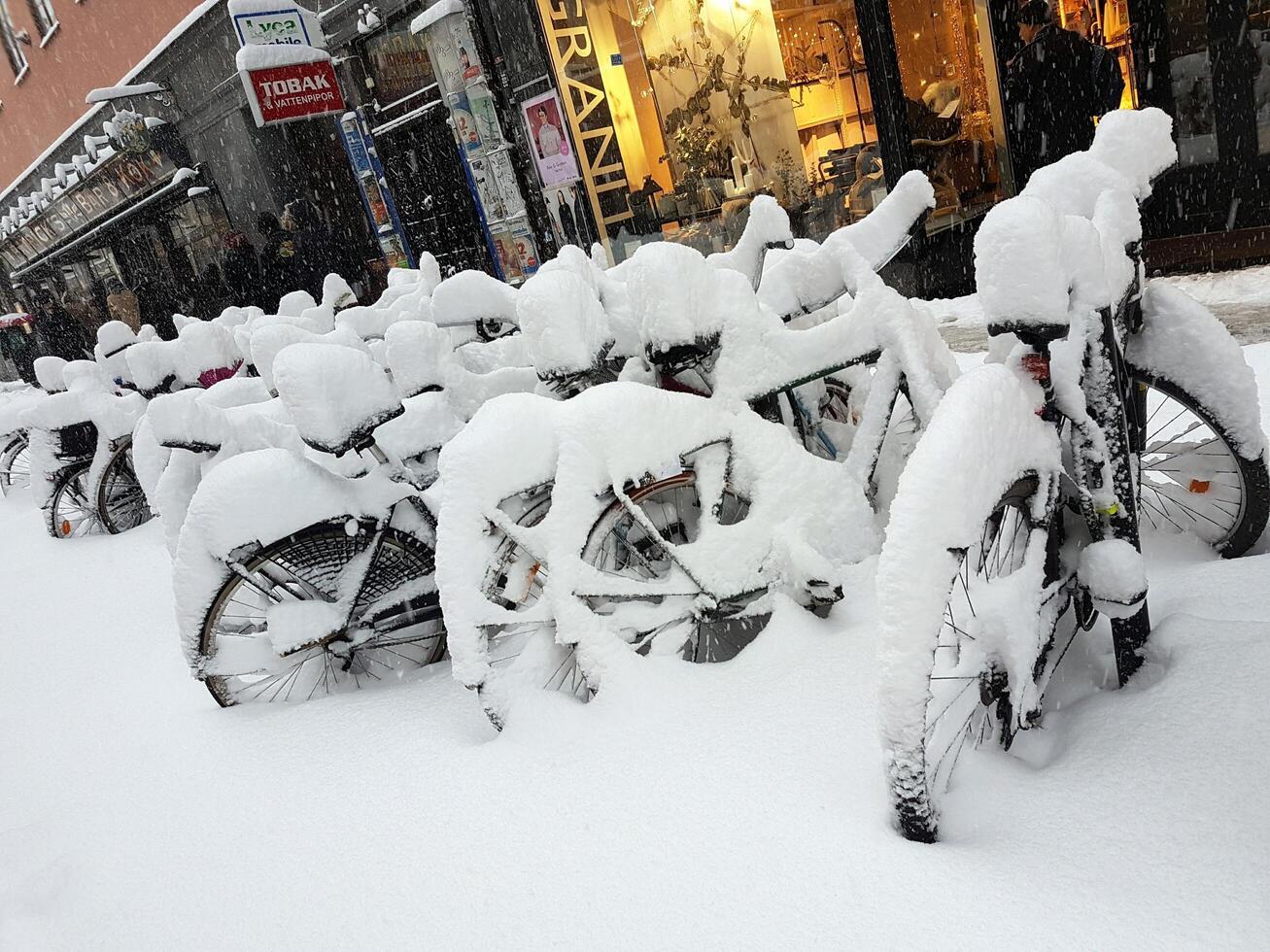 bicicletas sumergido por nieve en invierno en Estocolmo foto