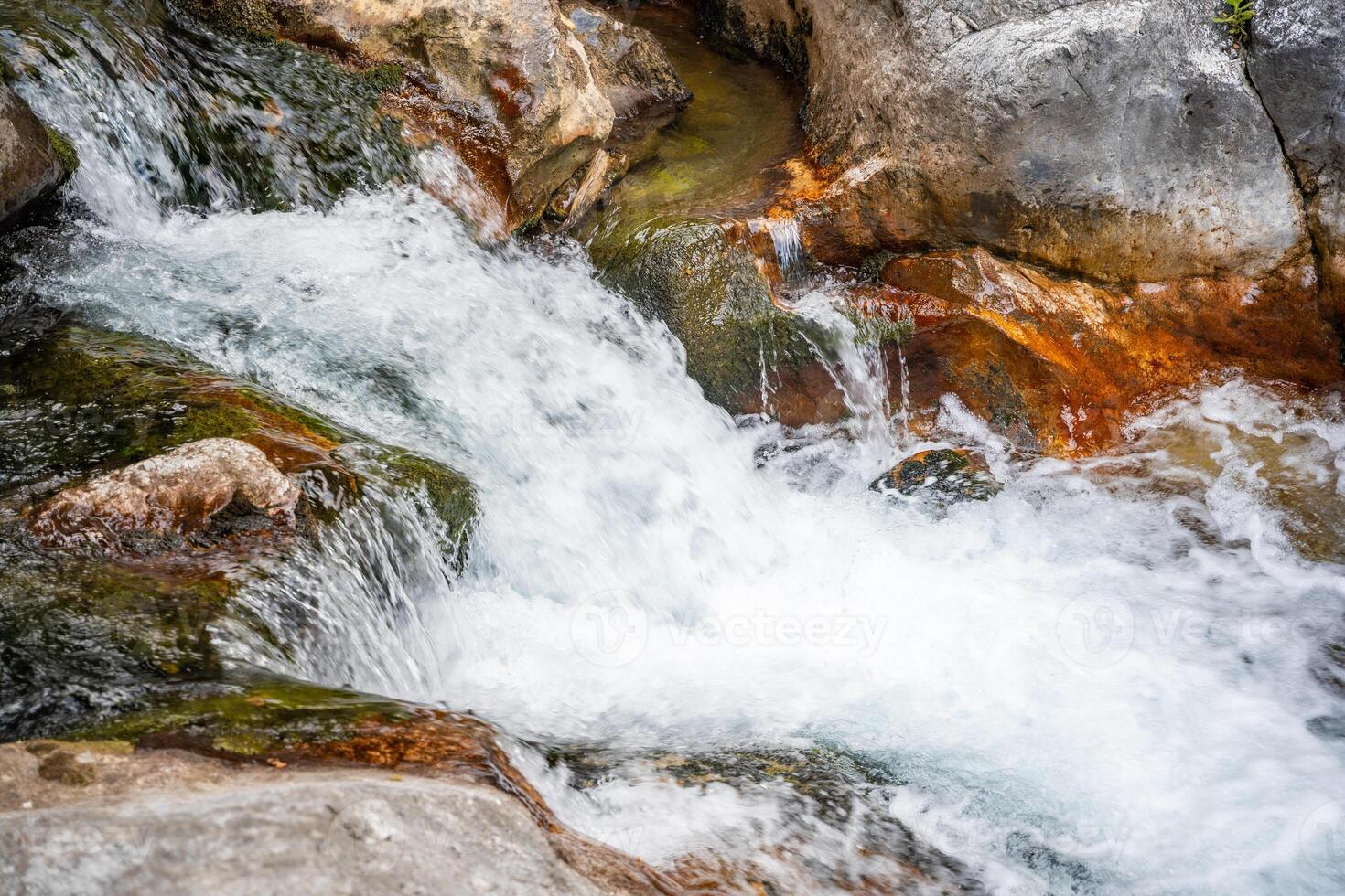 Fast flowing water in Sapadere canyon with rocks and stones in the Taurus mountains near Alanya, Turkey photo