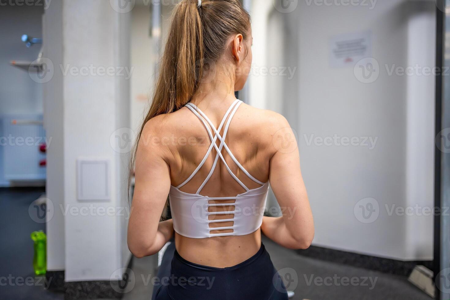 Young sport woman wearing sport wear doing exercise with fitness equipment at gym, she exercise for strong back and good healthy photo