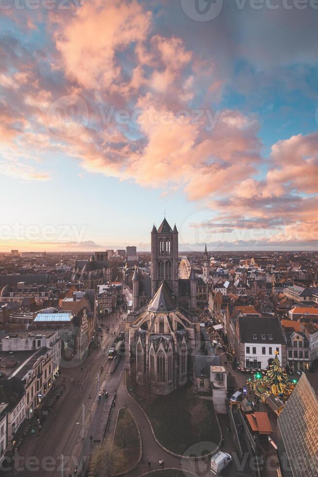 Watching the sunset over Ghent from the historic tower in the city centre. Romantic colours in the sky. Red light illuminating Ghent, Flanders region, Belgium photo