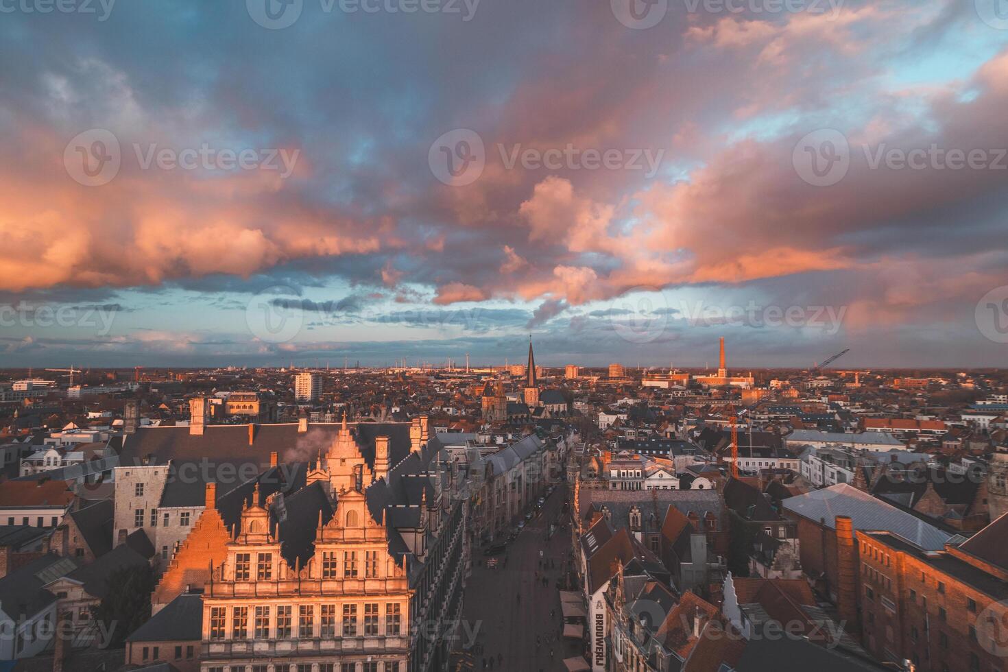 Watching the sunset over Ghent from the historic tower in the city centre. Romantic colours in the sky. Red light illuminating Ghent, Flanders region, Belgium photo