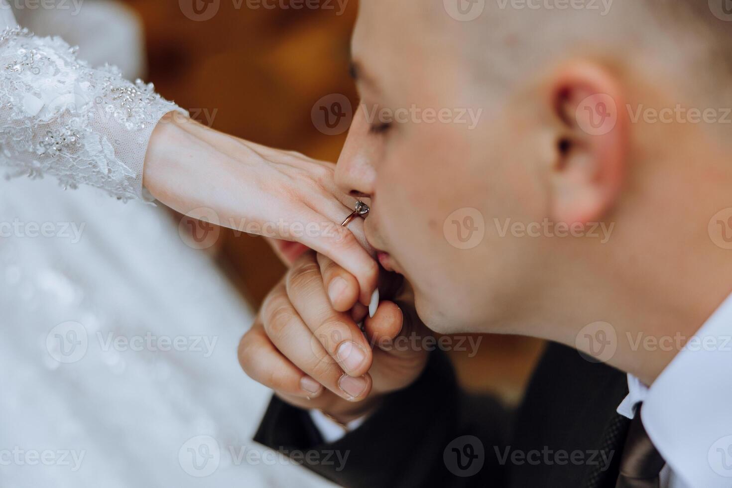 The groom kisses the bride's hand. Wedding photo of a couple in love. A young and handsome man kissing his wife's hand with a gold ring, proposing.