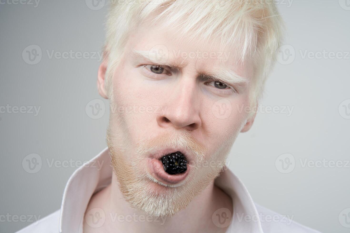 portrait of an albino man in studio dressed t-shirt isolated on a white background. abnormal deviations. unusual appearance photo