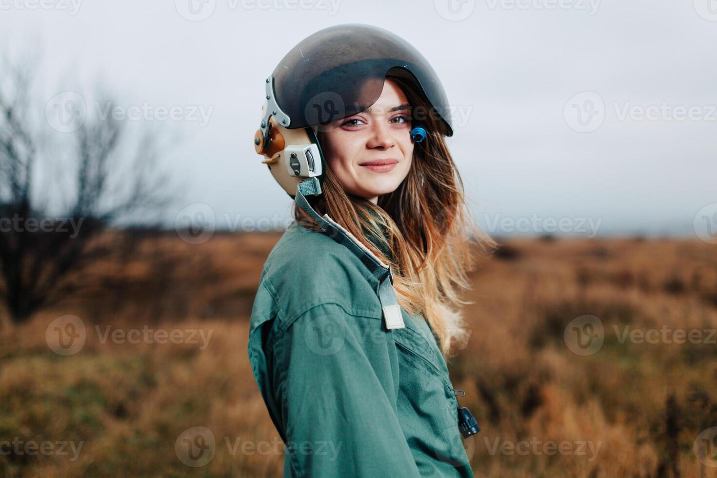 beautiful woman pilot of plane standing in the sunset field photo