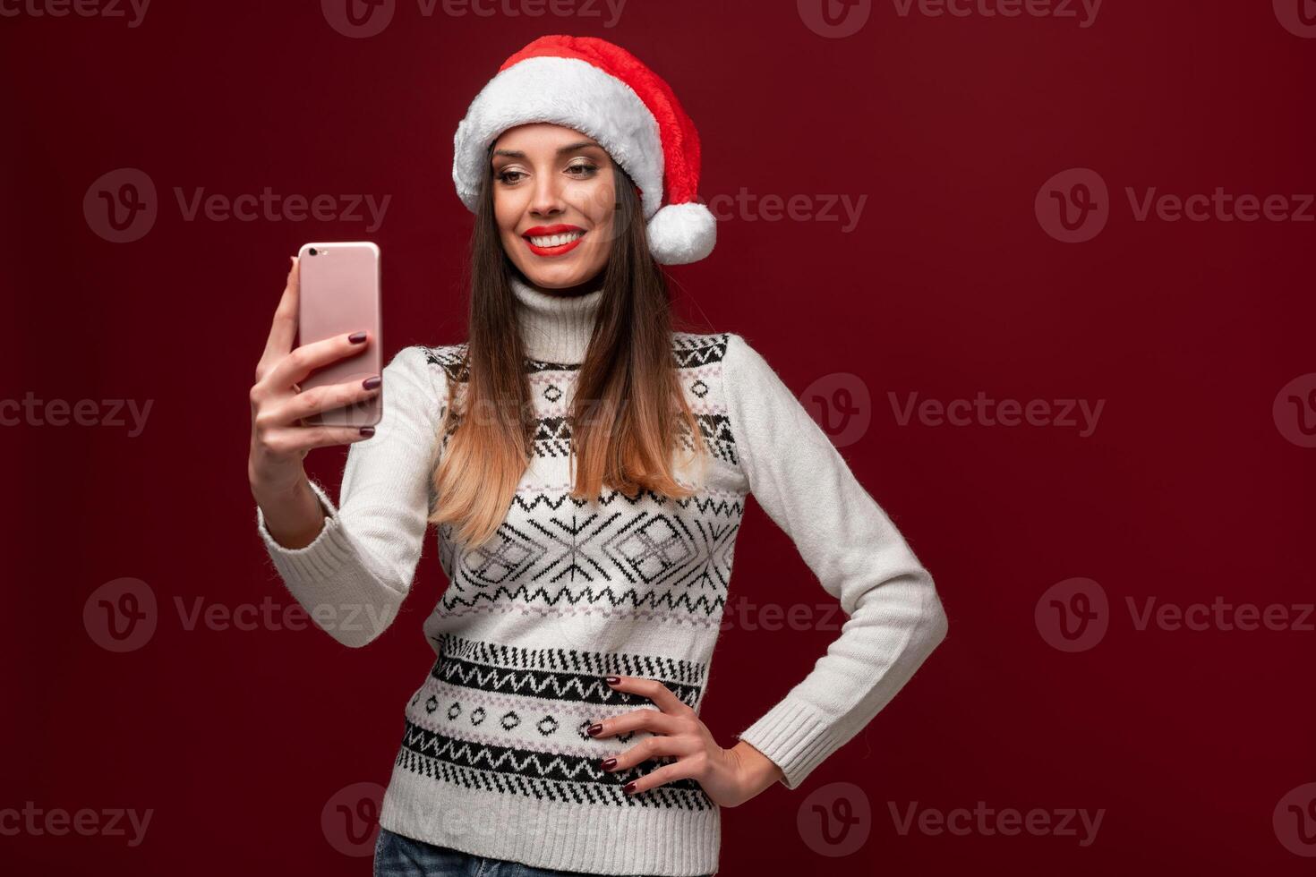 Close up portrait beautifiul caucasian woman in red Santa hat on red studio background. Christmas and New Year holiday concept. photo