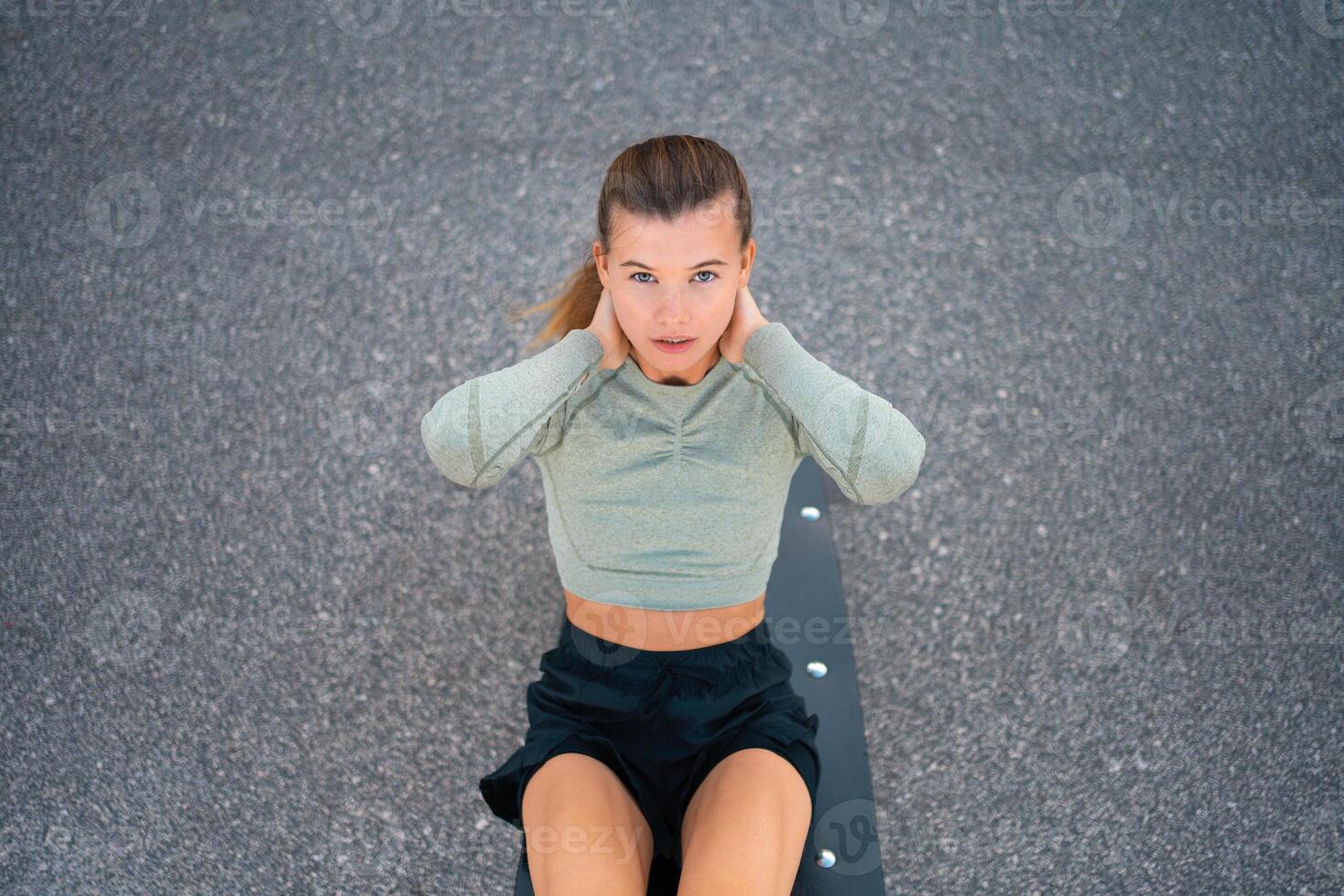 Sit-ups exercises. Active, fit sporty woman doing situps, exercising and training for fitness outdoor gym photo