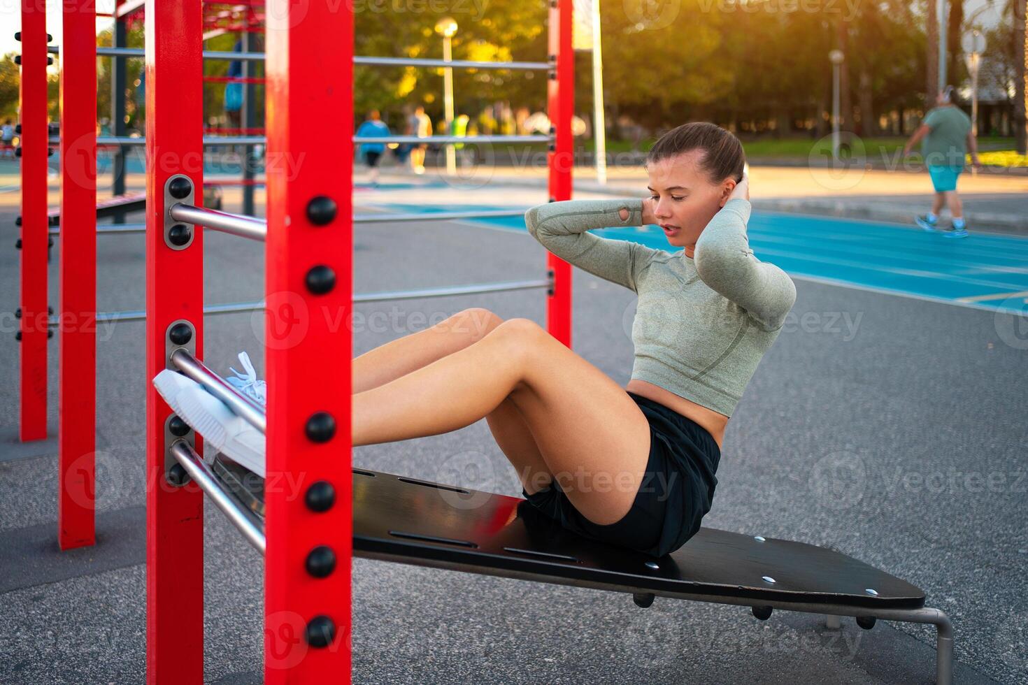 Sit-ups exercises. Active, fit sporty woman doing situps, exercising and training for fitness outdoor gym photo