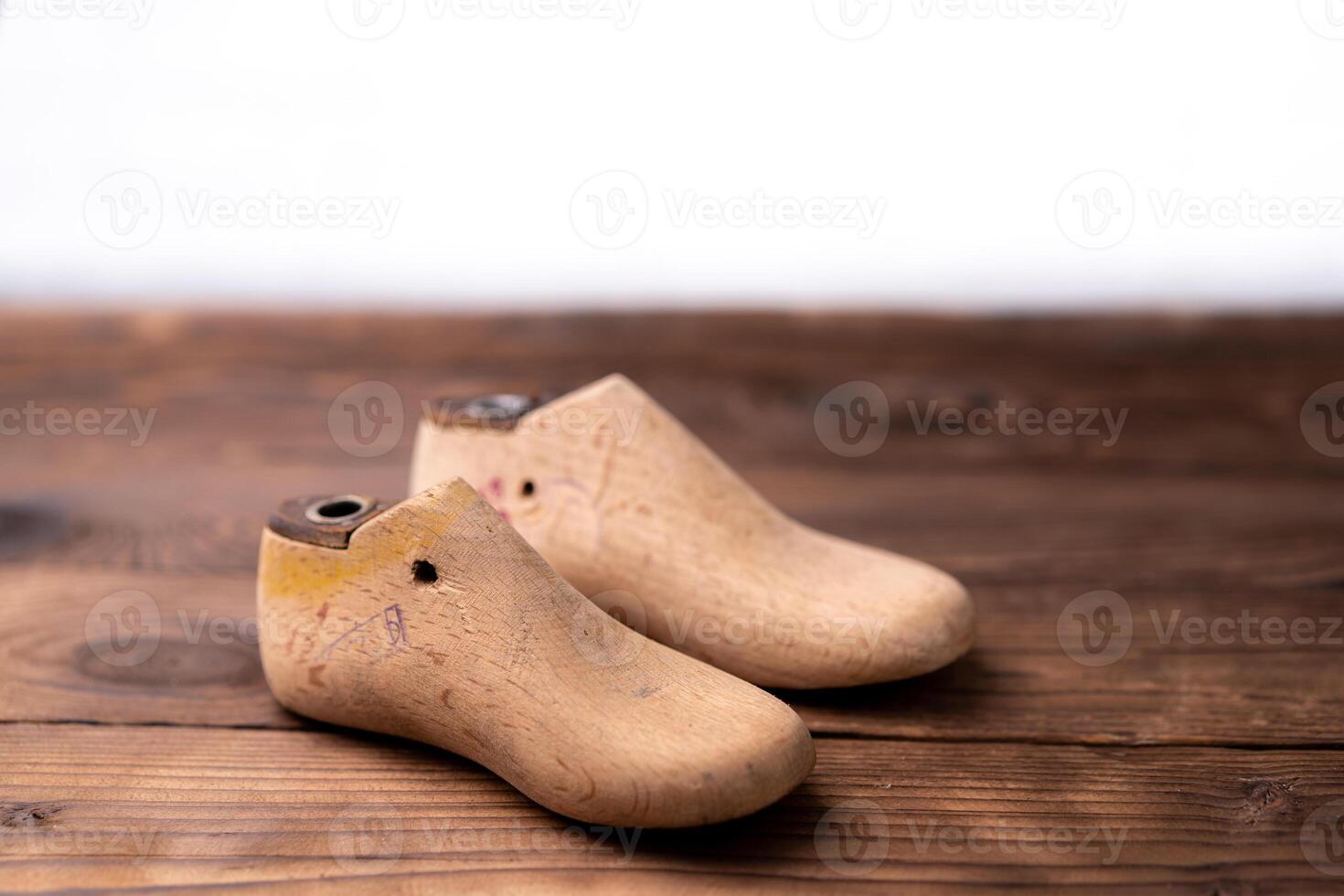 Leather samples for shoes and wooden shoe last on dark wooden table. photo