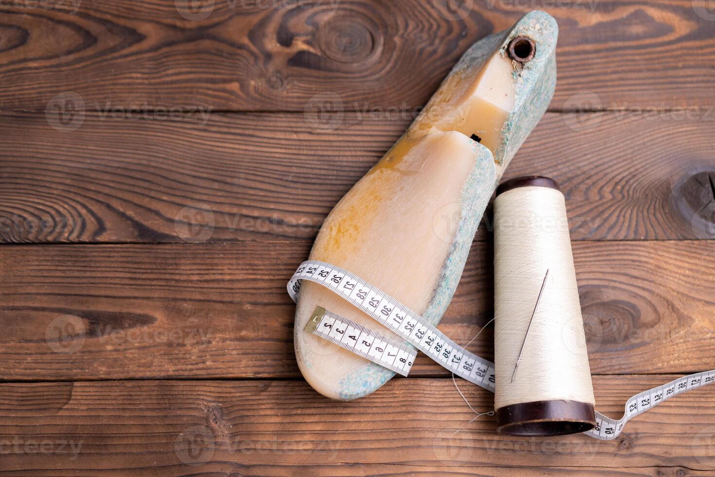 Leather samples for shoes and wooden shoe last on dark wooden table. photo