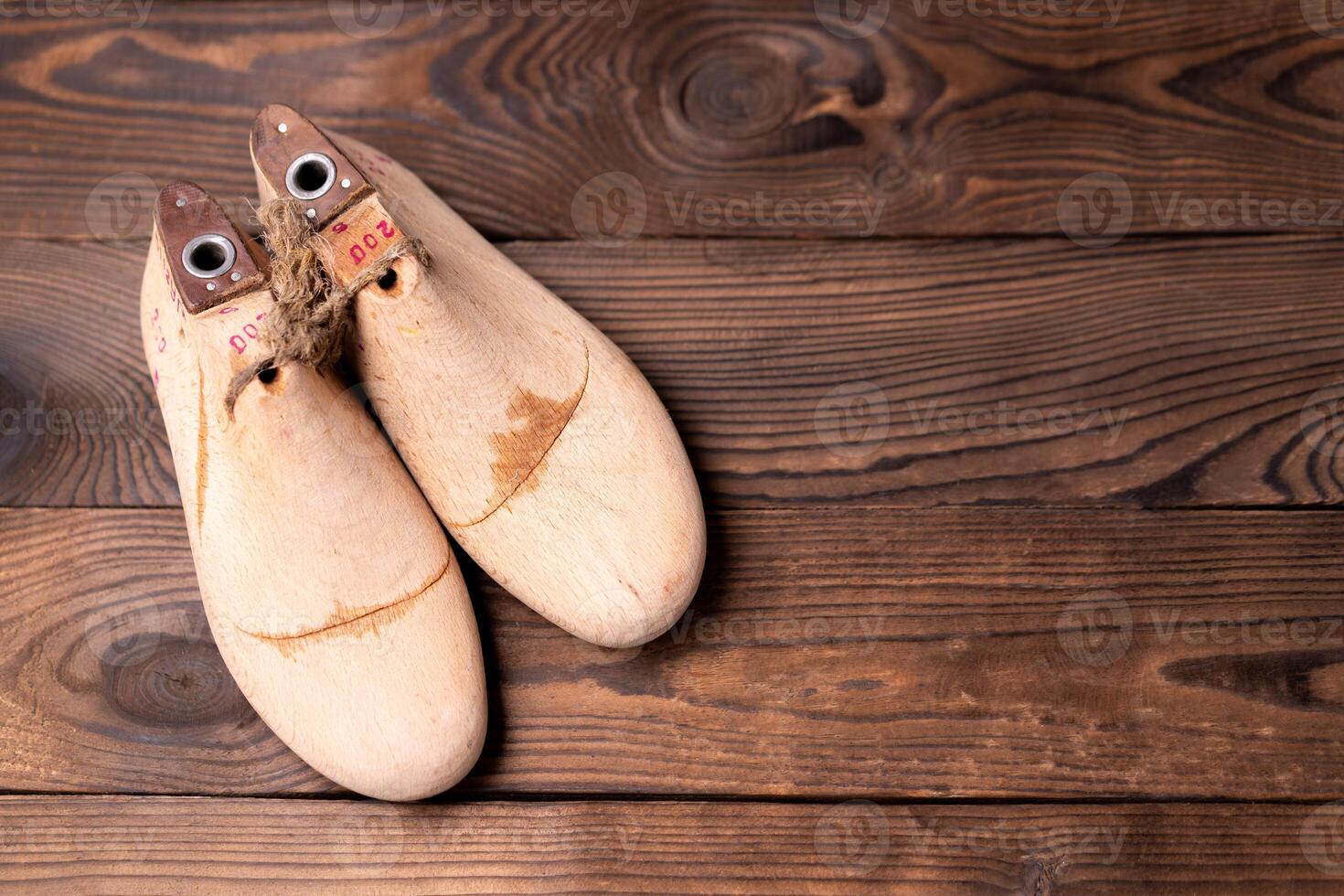 Leather samples for shoes and wooden shoe last on dark wooden table. photo