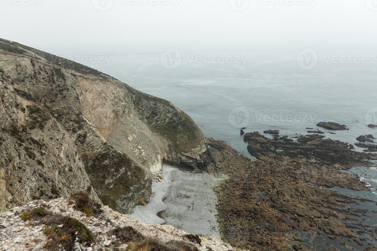 Summer Atlantic rocky coast view Big stony rockfall on precipice shore and ocean surf waves. Crozon, France View near the Memorial naval aviation Cape of the Goat May 2018 photo