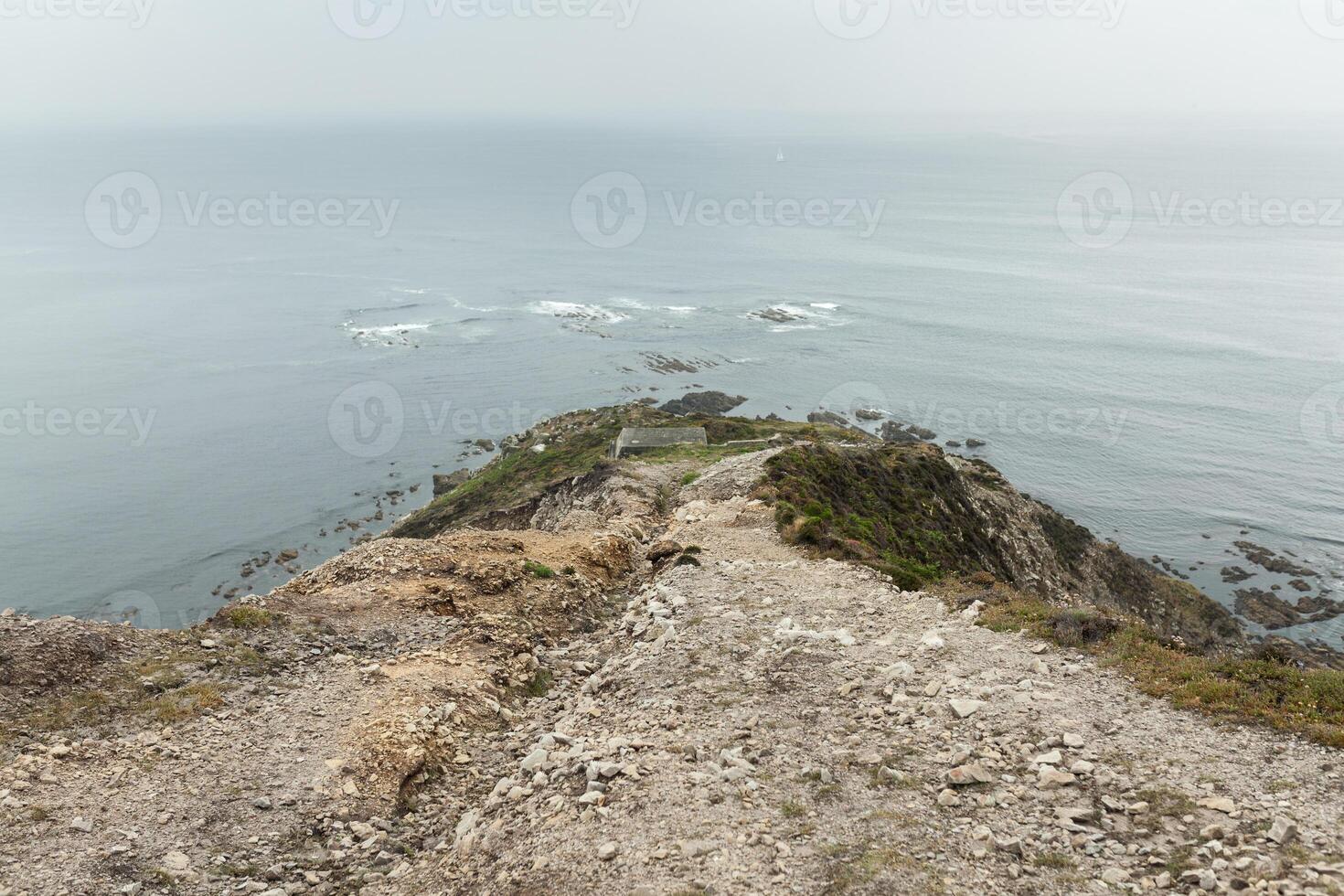Summer Atlantic rocky coast view Big stony rockfall on precipice shore and ocean surf waves. Crozon, France View near the Memorial naval aviation Cape of the Goat May 2018 photo