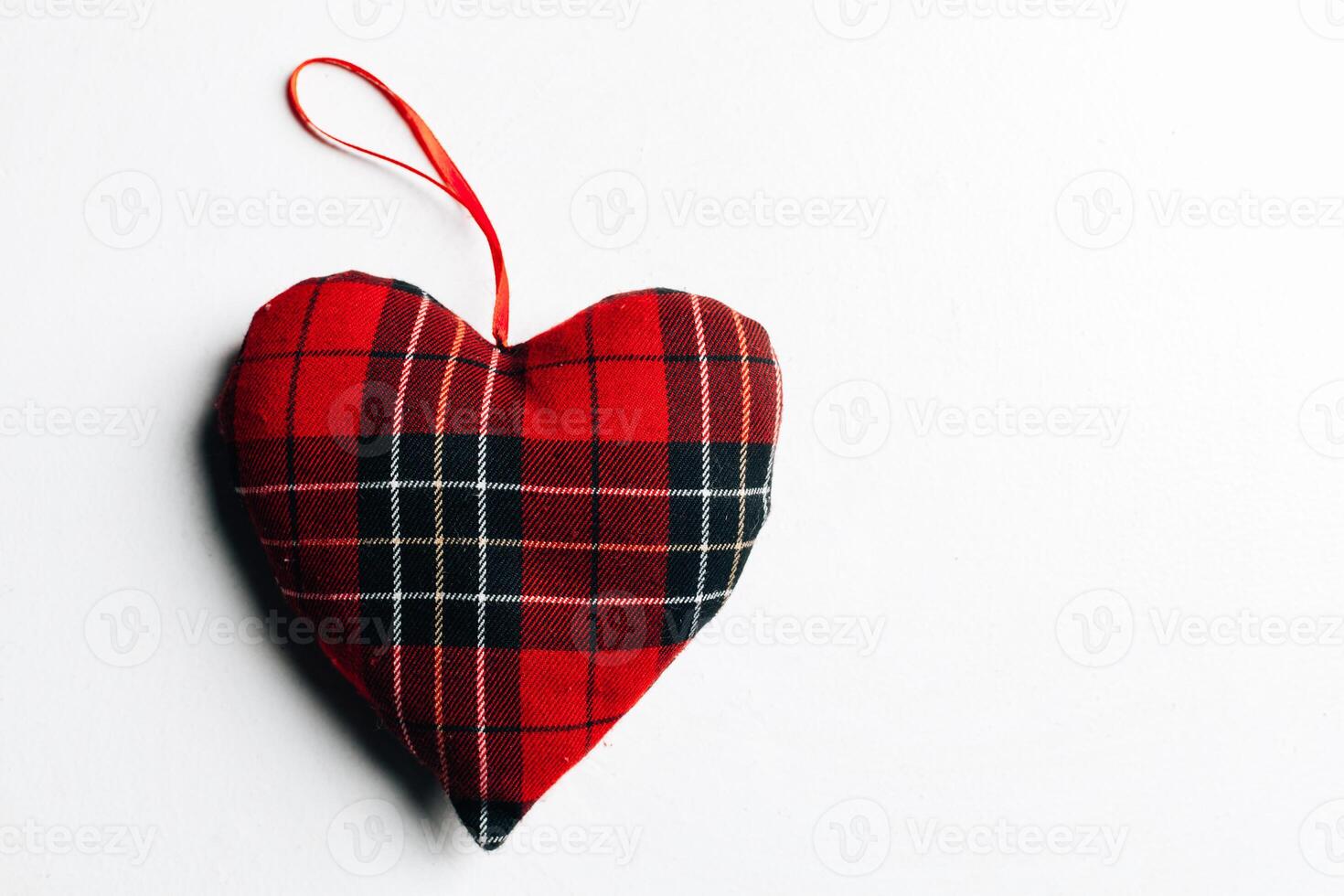 The checkered red fabric heart in the middle,free space for texts isolated on white background.Concept Valentine photo