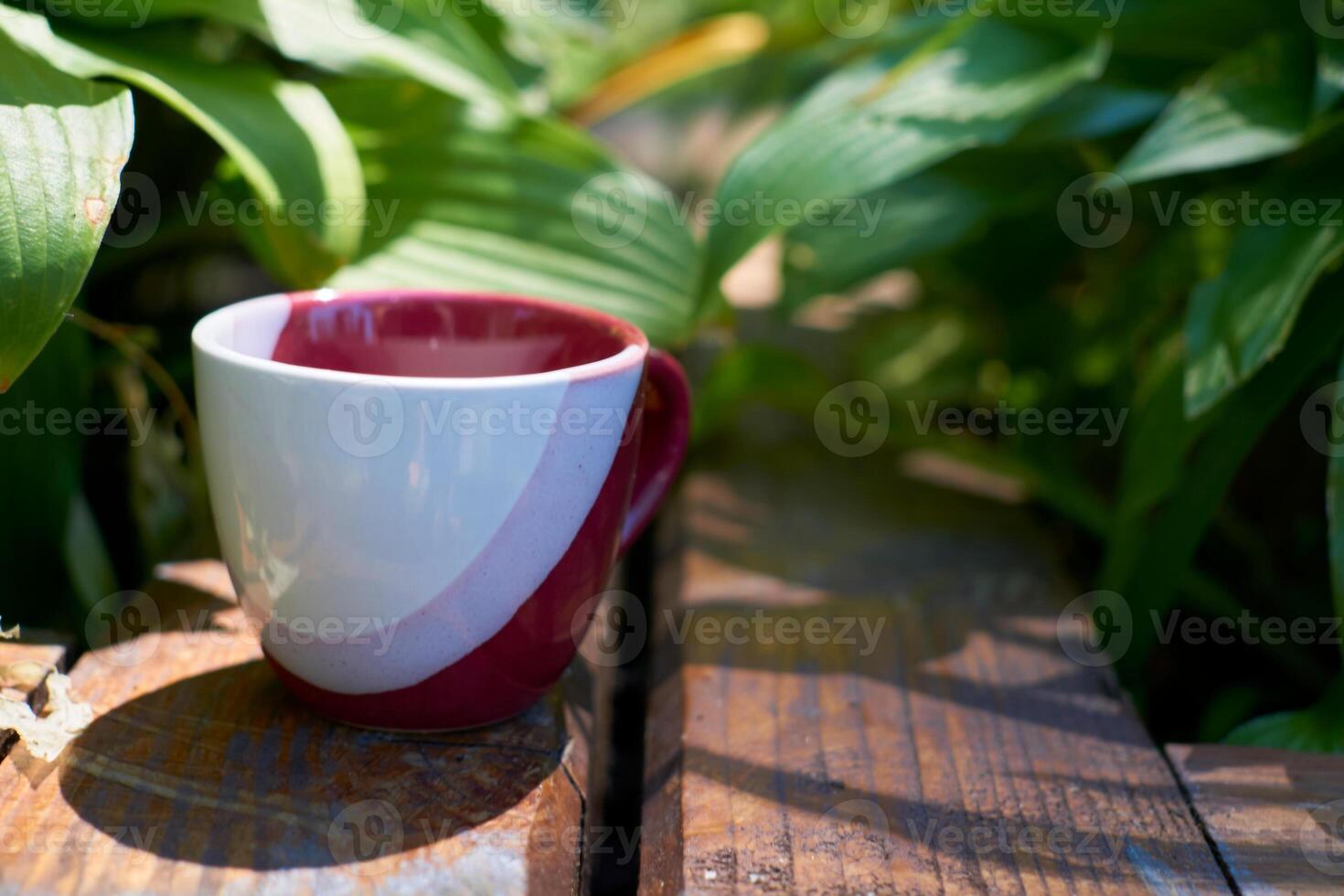 Teatime. tea coffee cup in greenery on a wood surface photo