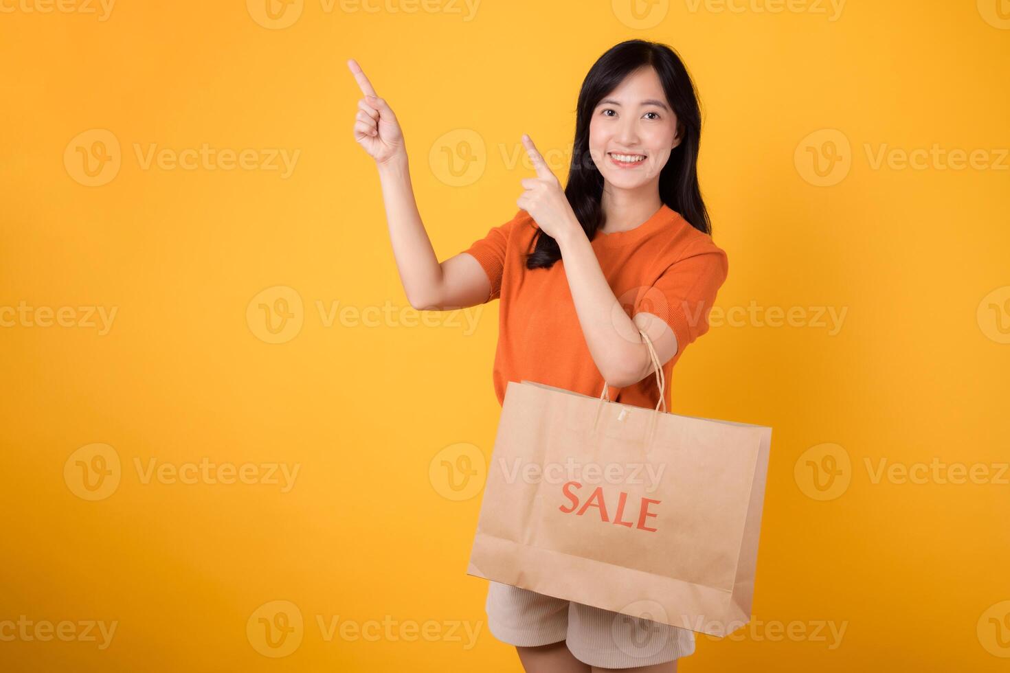 conocedor de la moda asiático mujer señalando a bolsas, demostración apagado su compras recorrido durante un venta. elegante opciones y descuentos foto
