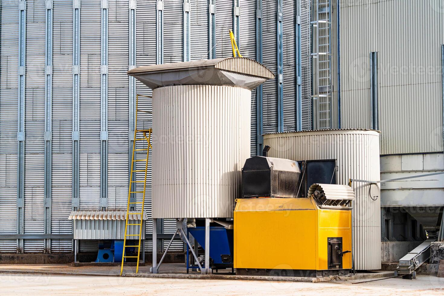 Individual metal containers at granary. Wheat preserving tanks at factory. Compartments for temporary grain storage. Closeup. photo