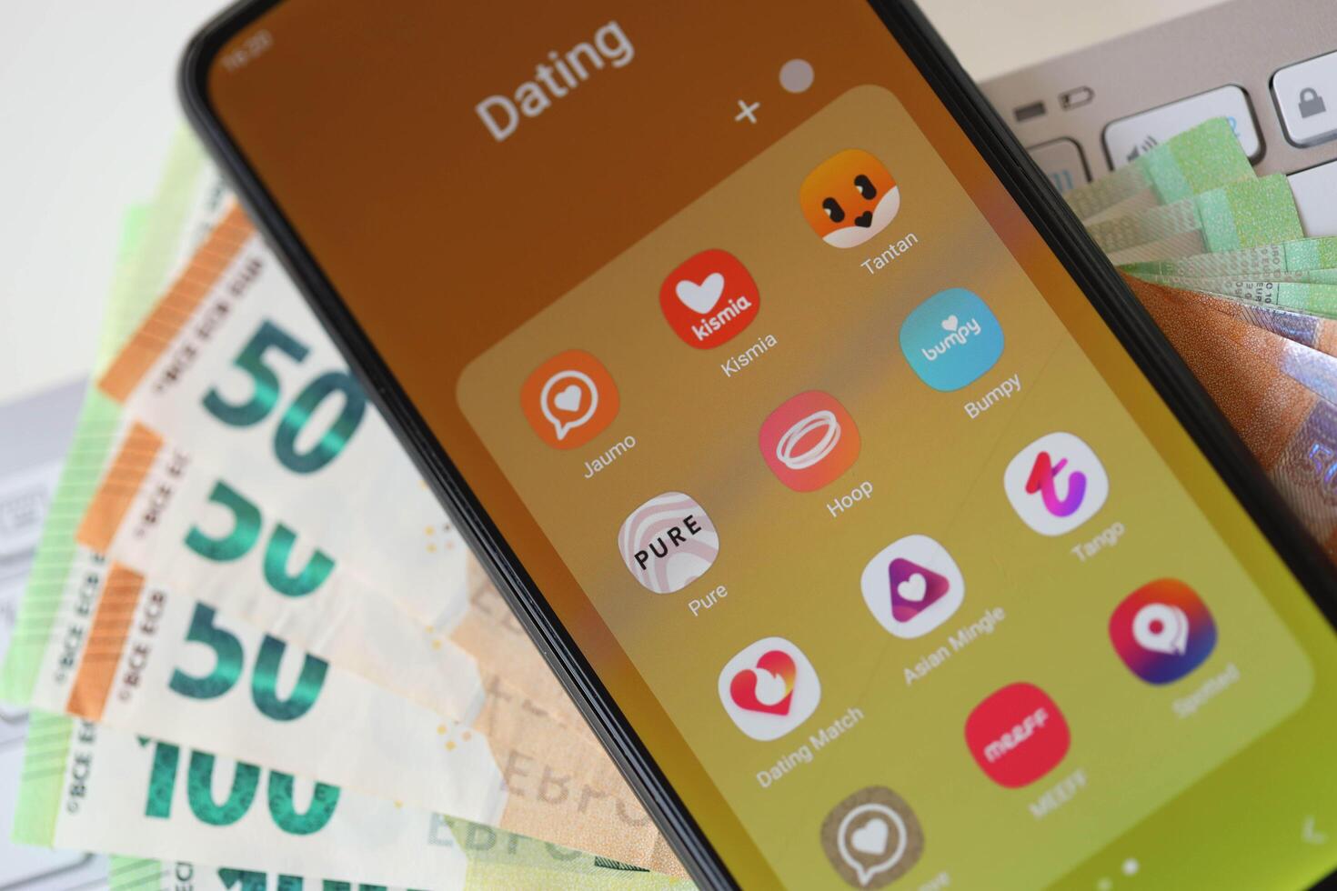 KYIV, UKRAINE - FEBRUARY 28, 2024 Dating apps icons on smartphone display and euro bills photo