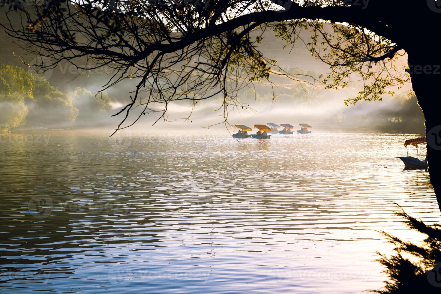 People in the paddleboats on the lake at sunset photo