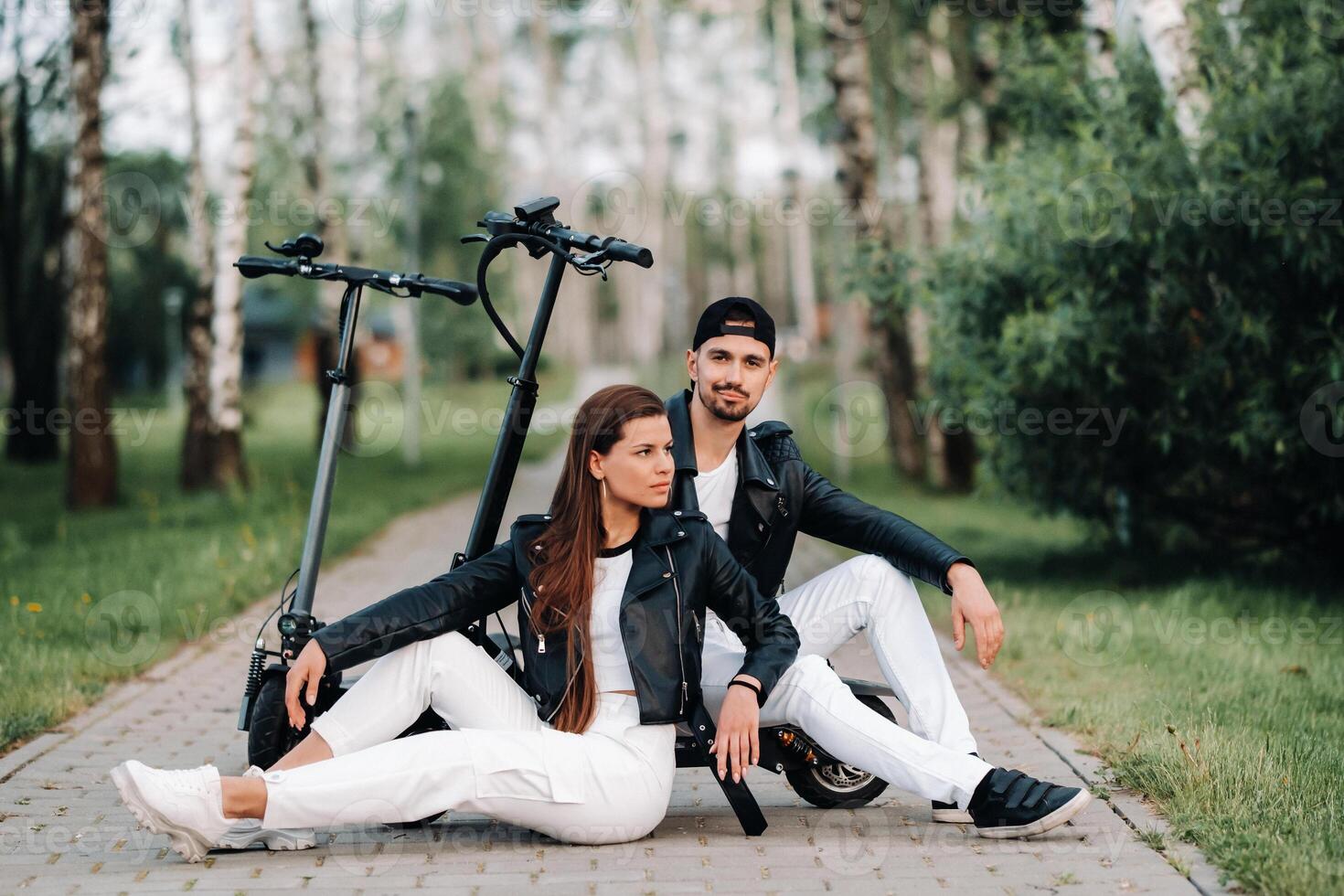 portrait of a couple sitting near electric scooters, enjoying time in nature together, Two lovers on electric scooters.People on scooters photo