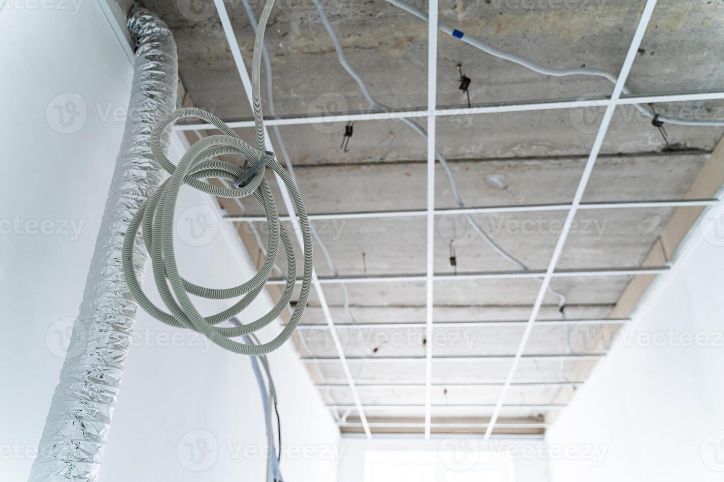 Newly repaired interior in white colors. Plasterboard ceiling. Air conditioner on the wall. Empty room. Closeup photo