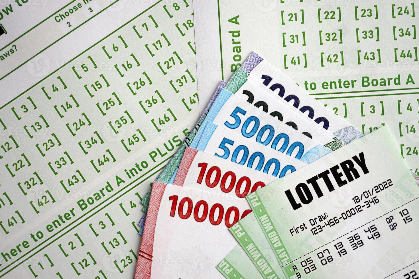 Green lottery tickets and indonesian money bills on blank with numbers for playing lottery photo