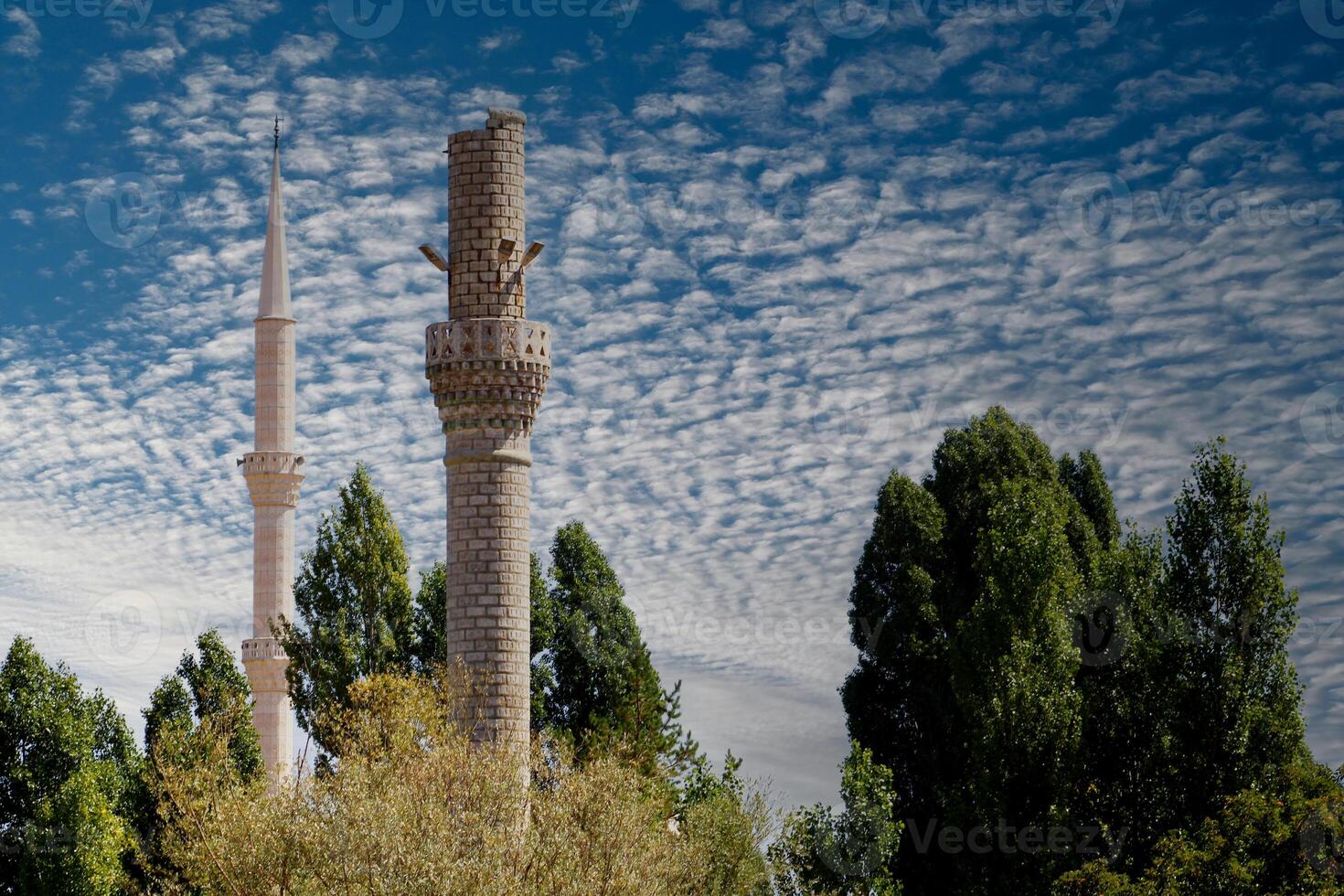 un antiguo destruido alminar y un sólido alminar foto