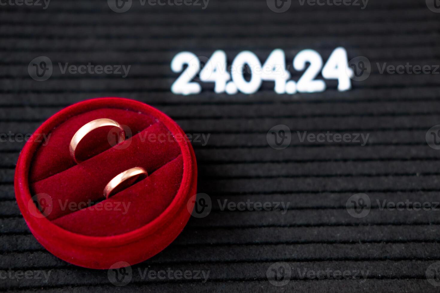 Rings of the newlyweds on the background of a Beautiful date for the wedding 04.24.2024 on a black lettobord photo