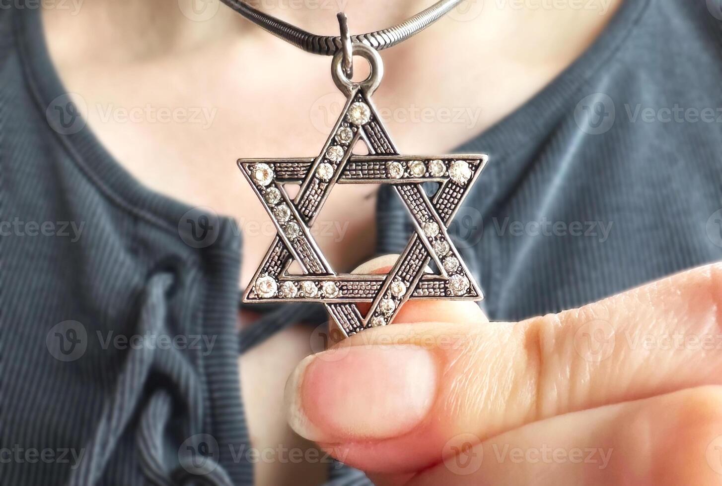 Young woman's hand holding a David Star Magen David key chain. The State of Israel, Judaism, Zionism concept image. Conversion to Judaism. Passover. photo