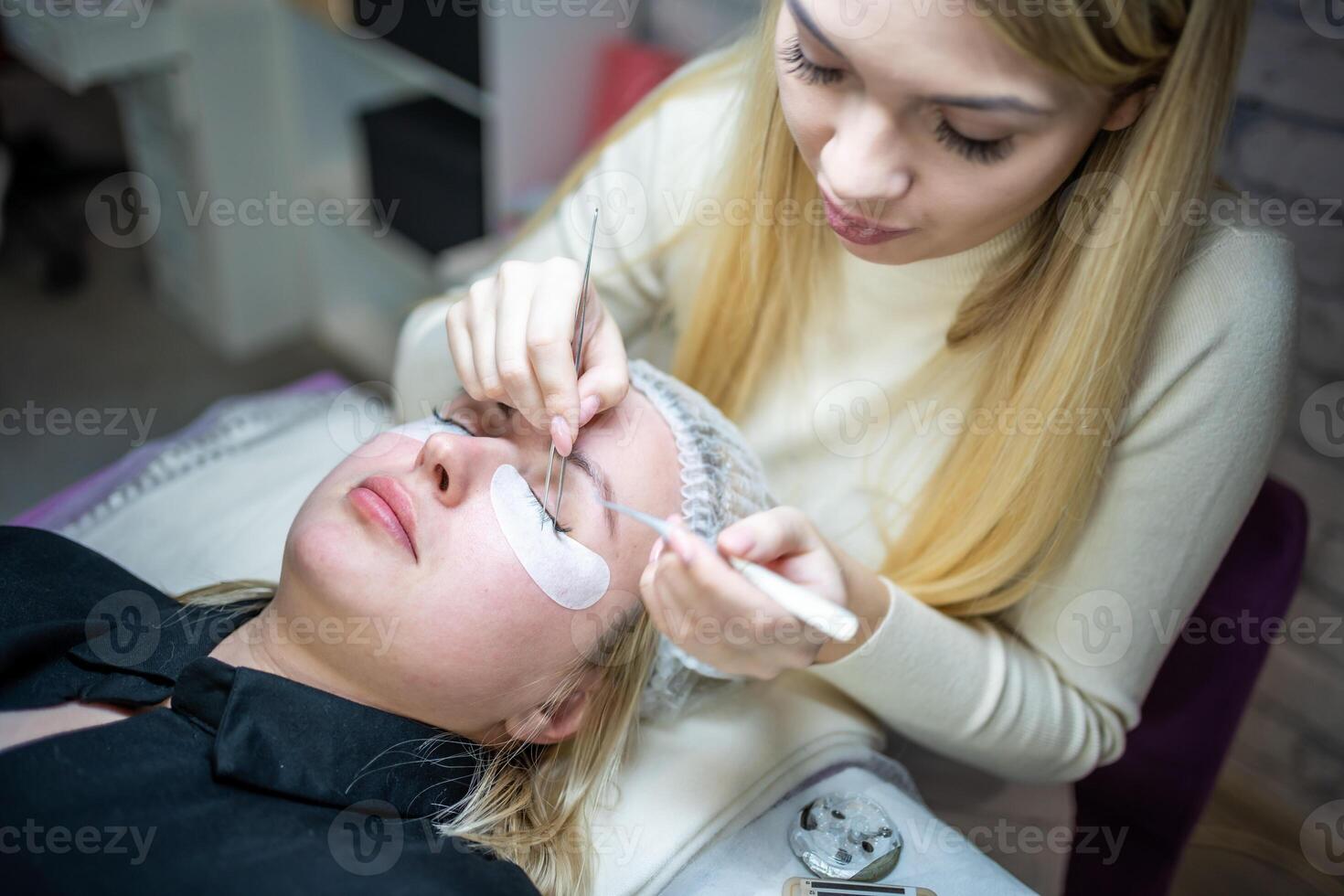 Eyelash extension procedure in beauty salon. Lashes close up. Concept spa lash. photo