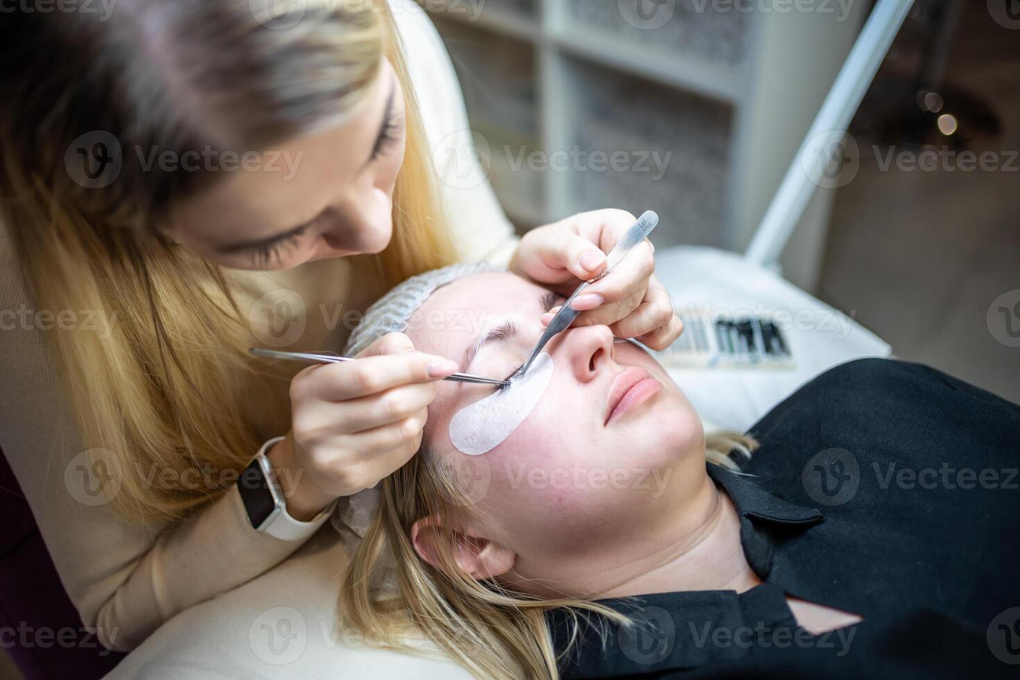 Eyelash extension procedure in beauty salon. Lashes close up. Concept spa lash. photo