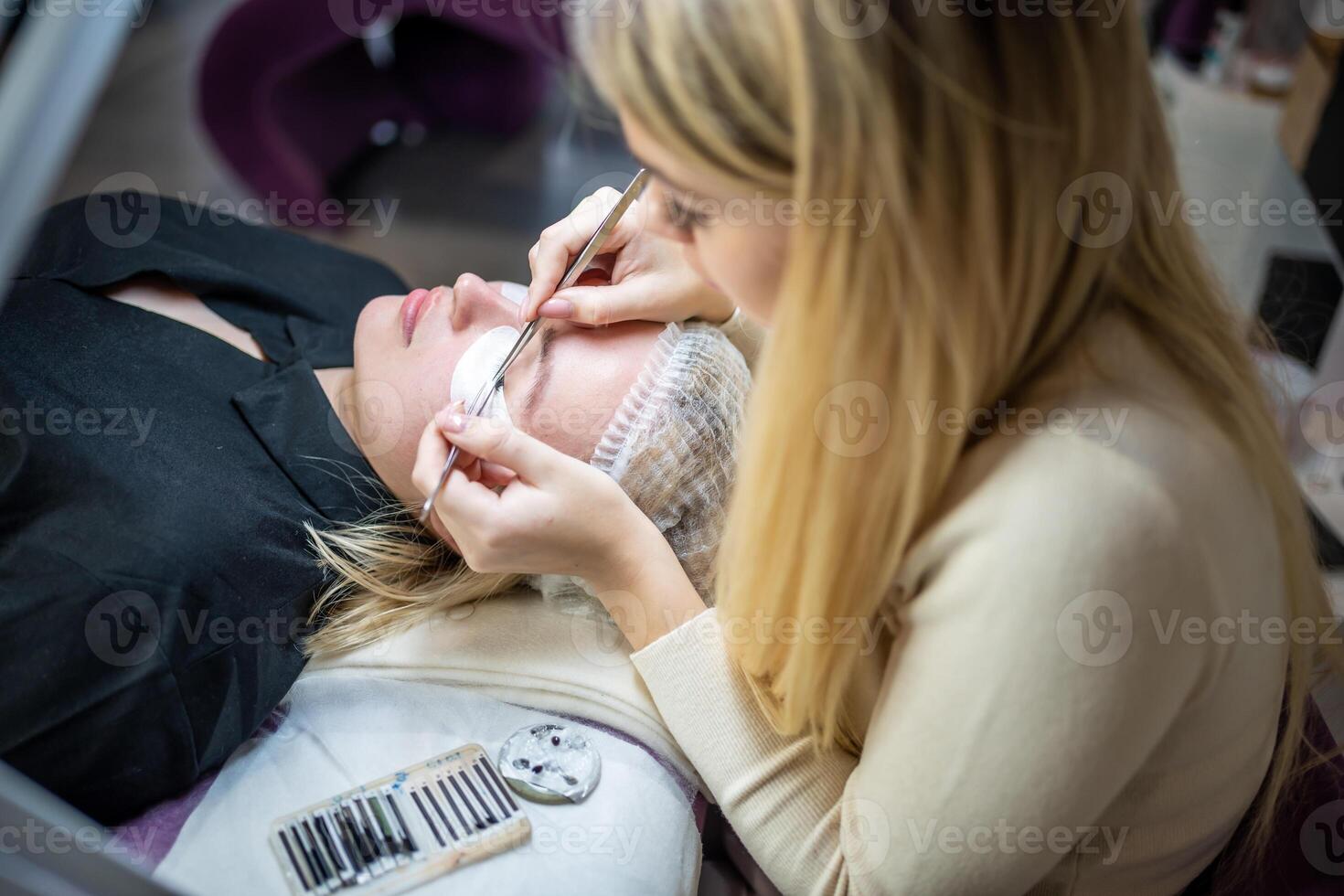 Eyelash extension procedure in beauty salon. Lashes close up. Concept spa lash. photo
