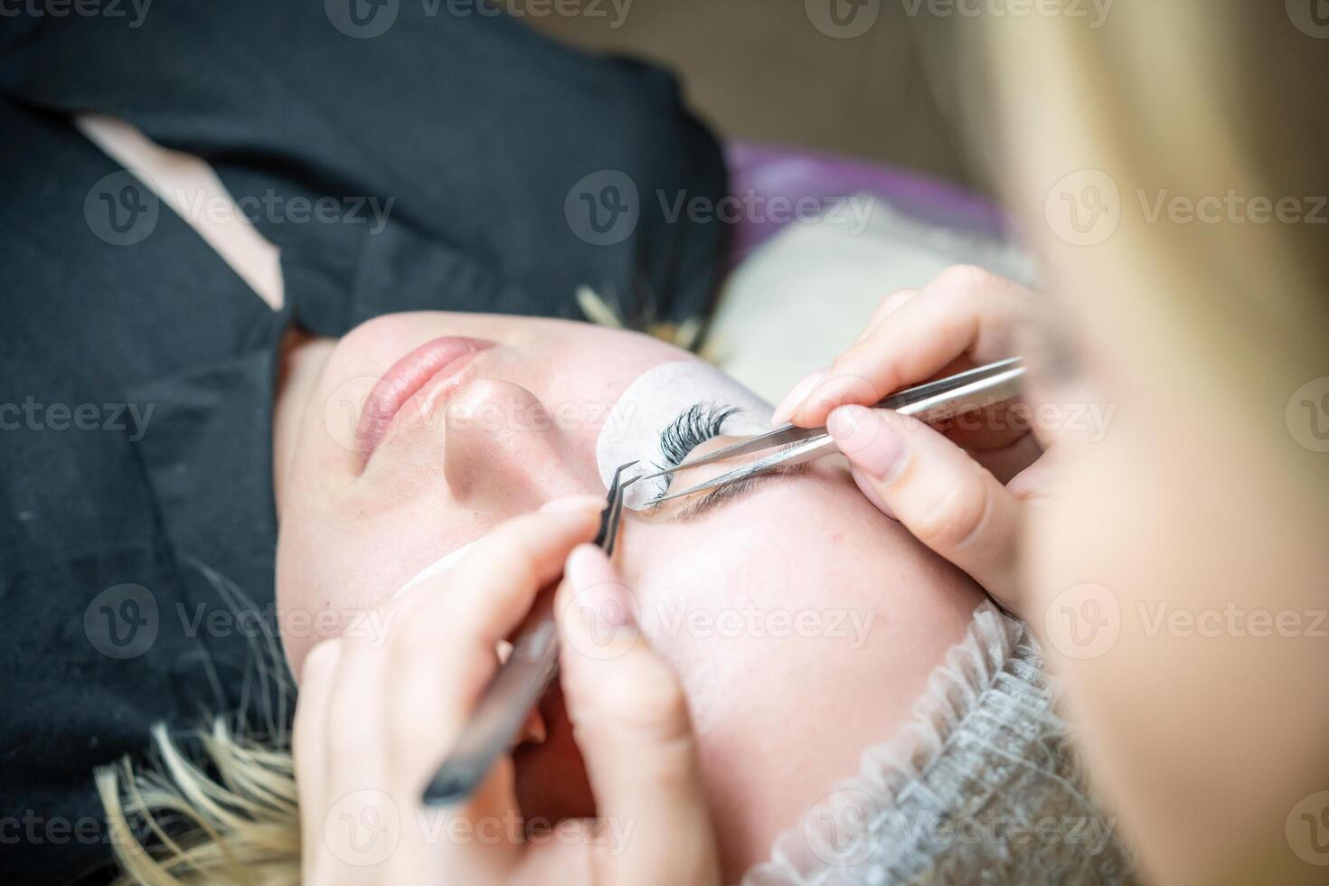 Eyelash extension procedure in beauty salon. Lashes close up. Concept spa lash. photo