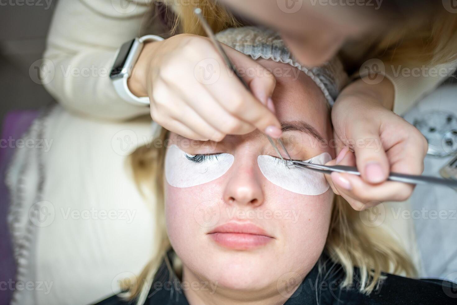 Eyelash extension procedure in beauty salon. Lashes close up. Concept spa lash. photo