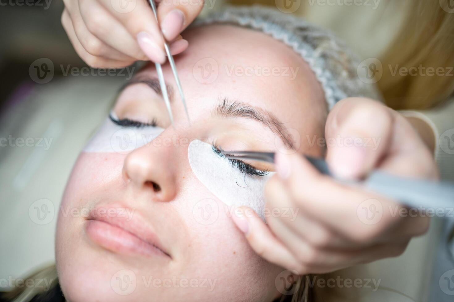 Eyelash extension procedure in beauty salon. Lashes close up. Concept spa lash. photo