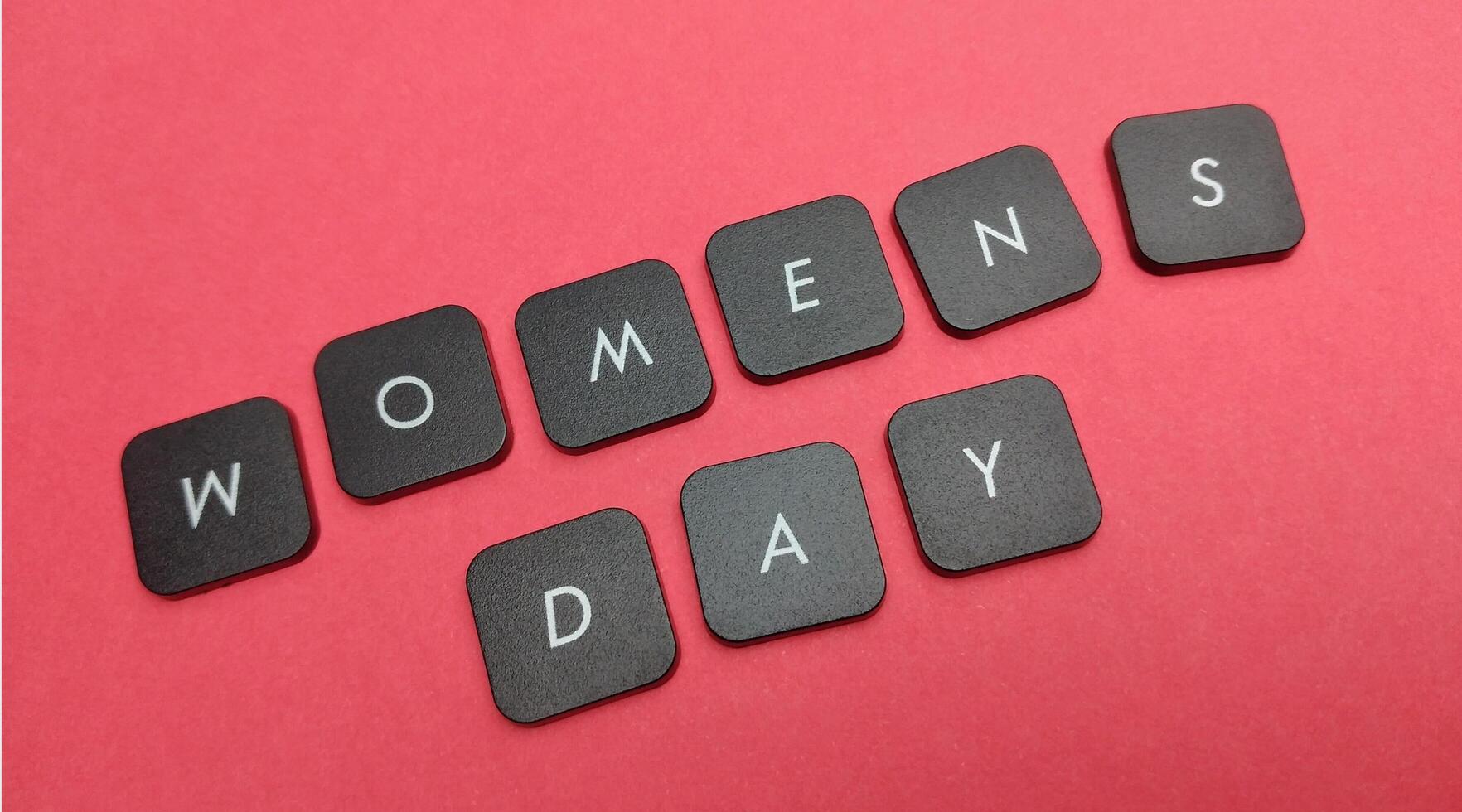 Words women's day made of black keyboard keys on red background. photo