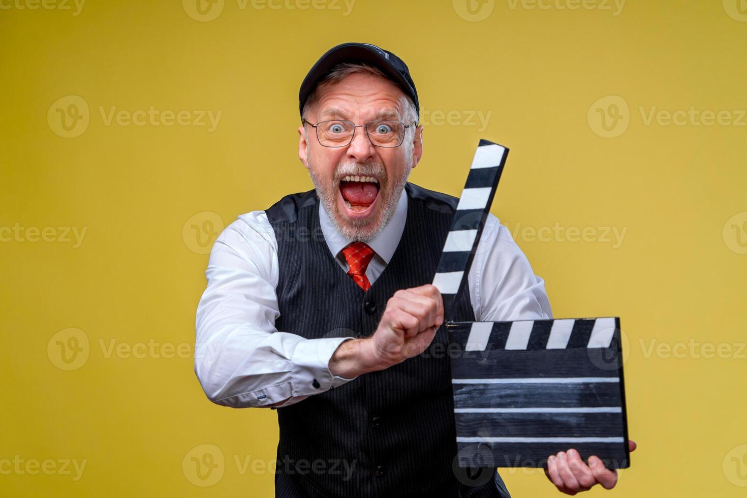 Senior man holds film flap close up. Film directing. Film production. Human emotions. Man with movie flap while filming photo