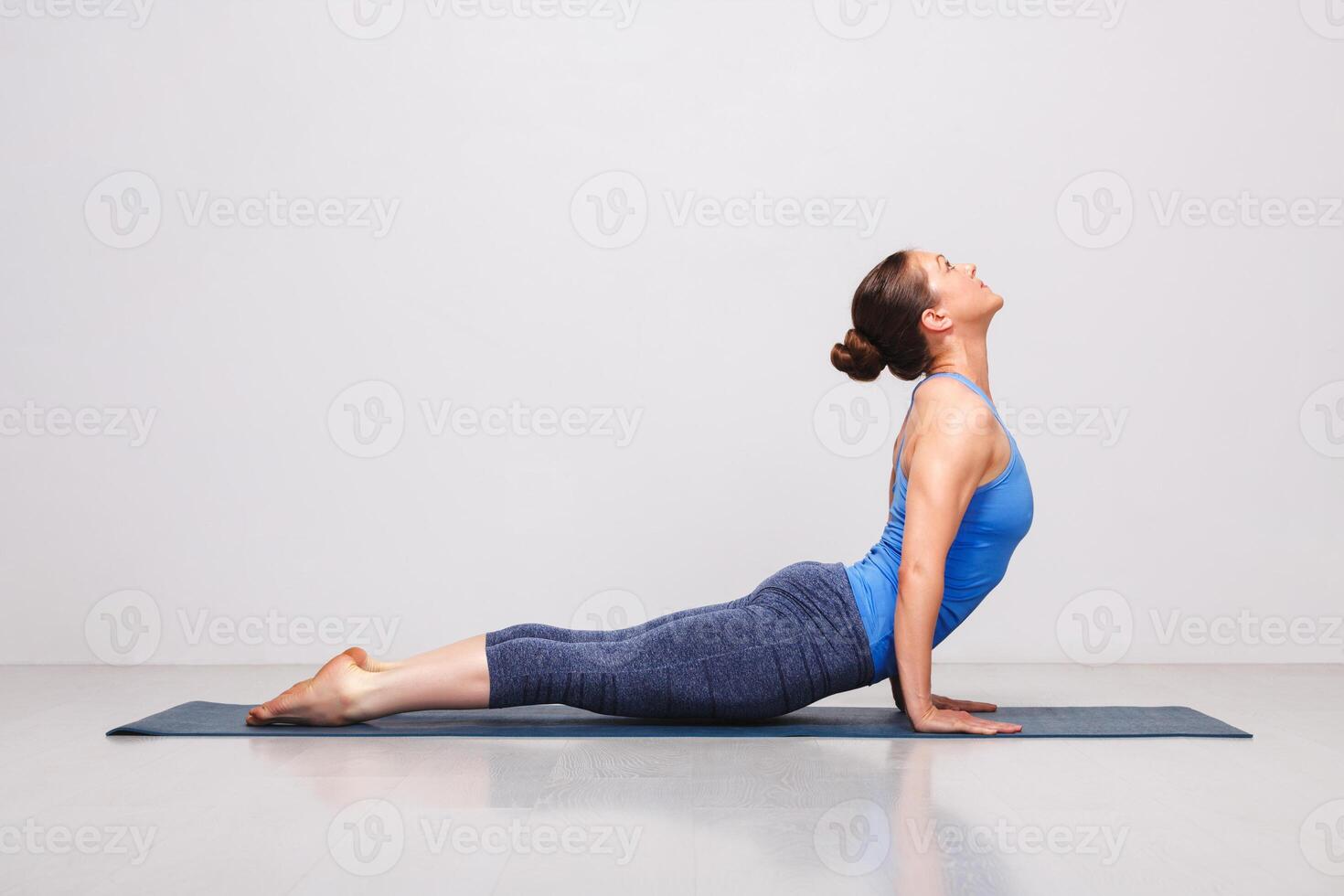 Woman doing Ashtanga Vinyasa yoga Sun Salutation asana Urdhva mu photo
