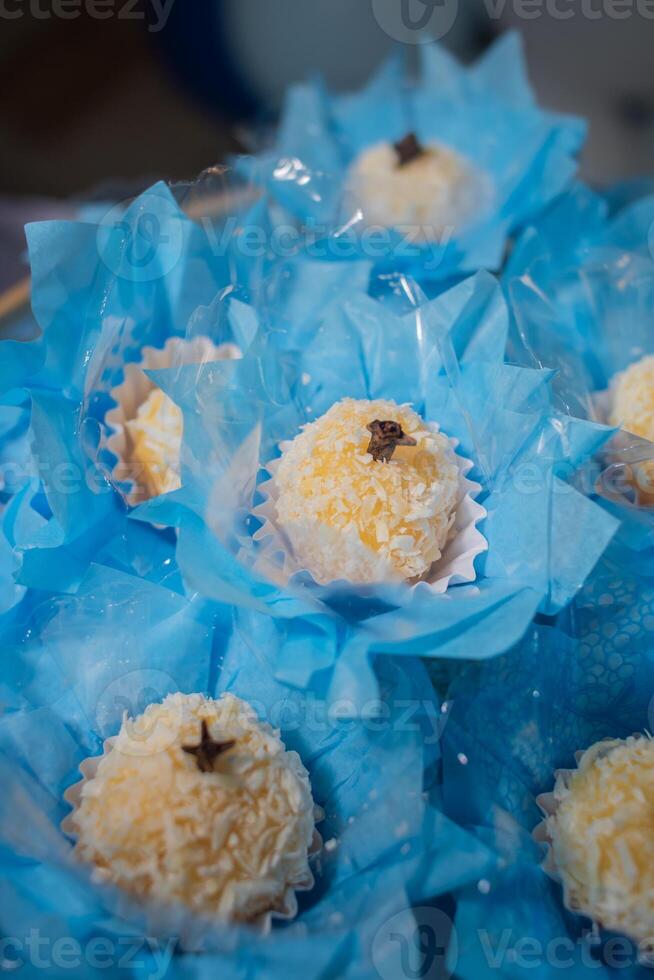 Brigadier. Decorated white brigadeiro, party sweet on blue paper photo