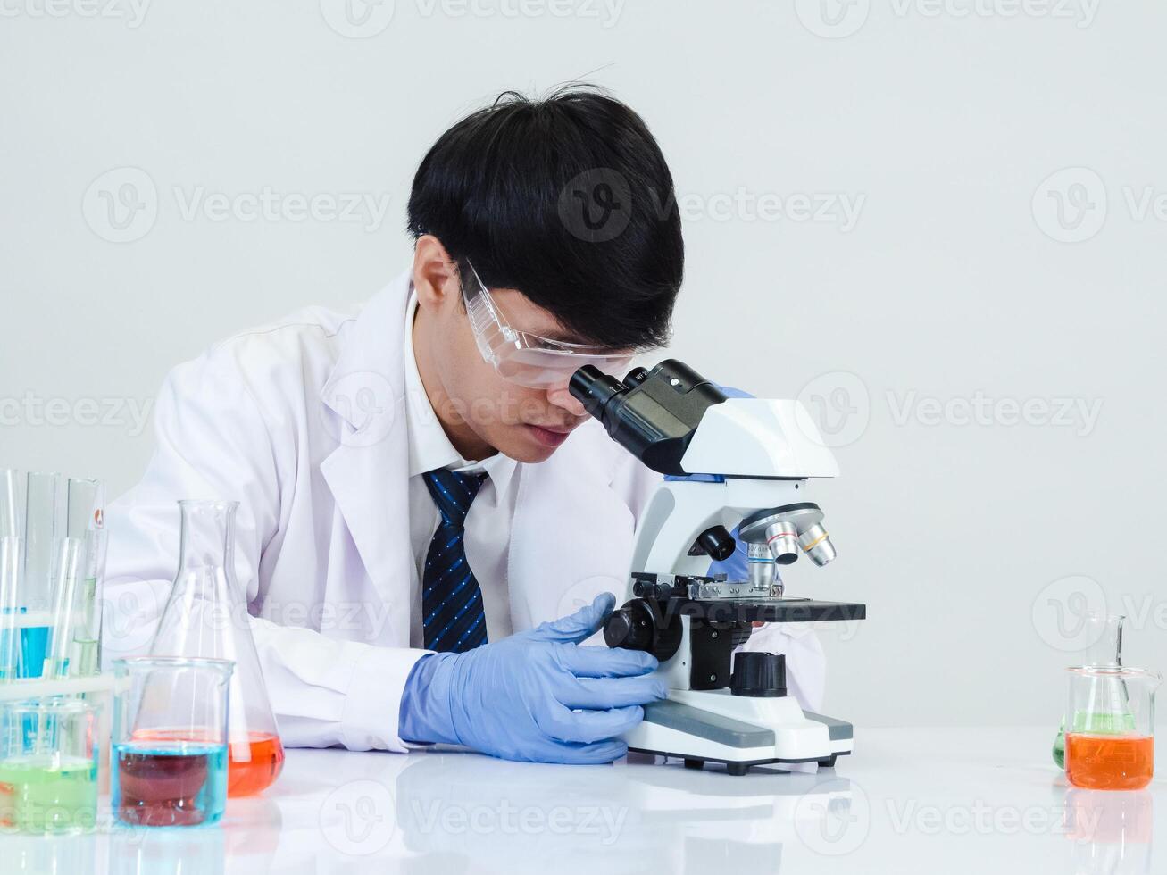 Portrait asian man student scientist doctor in shirt gown one person wokk job plant looking hand holding control microscope on white table see the results of scientific experiments inside laboratory photo