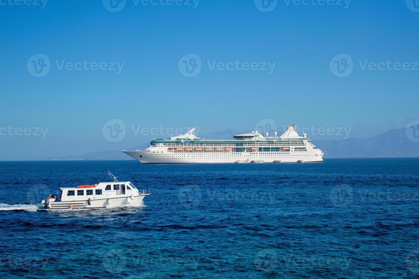 Boat and cruise liner is Aegean sea. Chora, Mykonos island, Greece photo