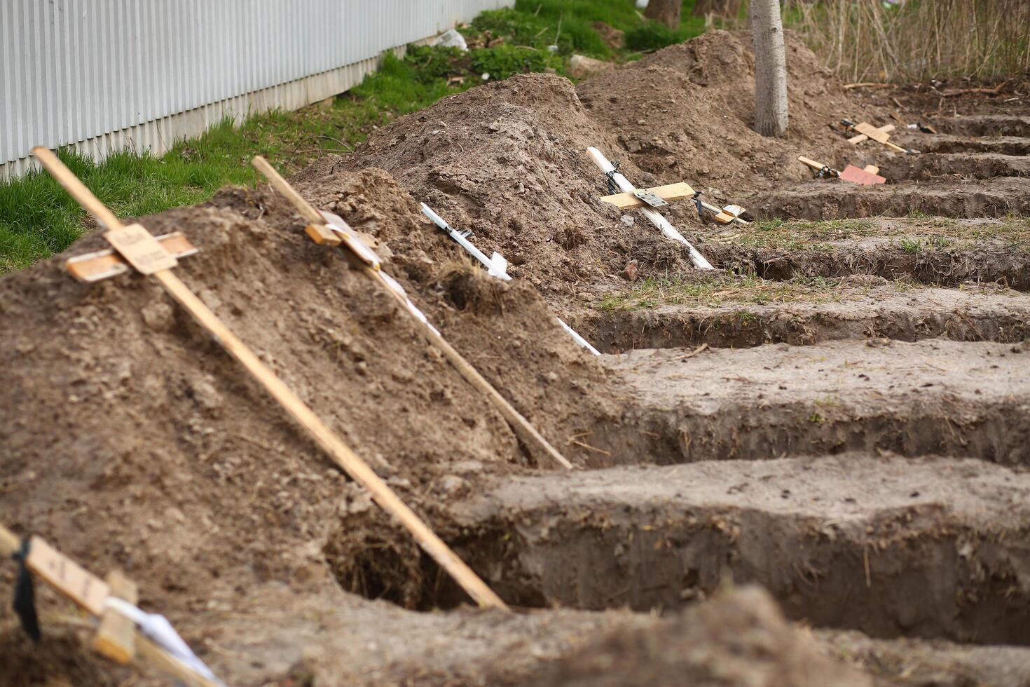 Bucha, Ukraine - April 12, 2022 Empty graves of the killed by the russian army civilans, buried by their neighbors in home yard, after exhumation of their bodies photo
