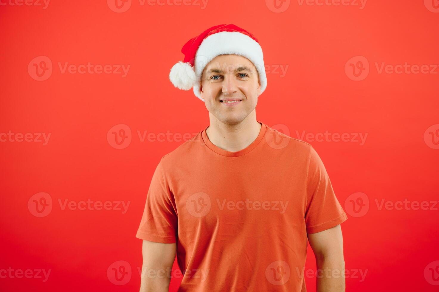 concept people, body language, approval, recommendationan excited man Santa Claus hat isolated on red studio background with space for text photo