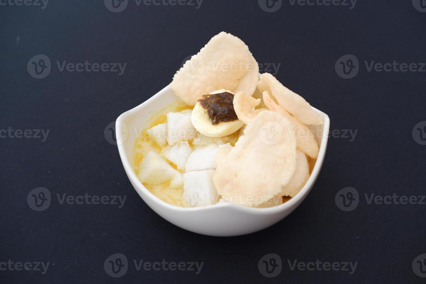 lontong sayur- Compressed rice cake served with curry coconut milk sauce and vegetables and boiled egg photo