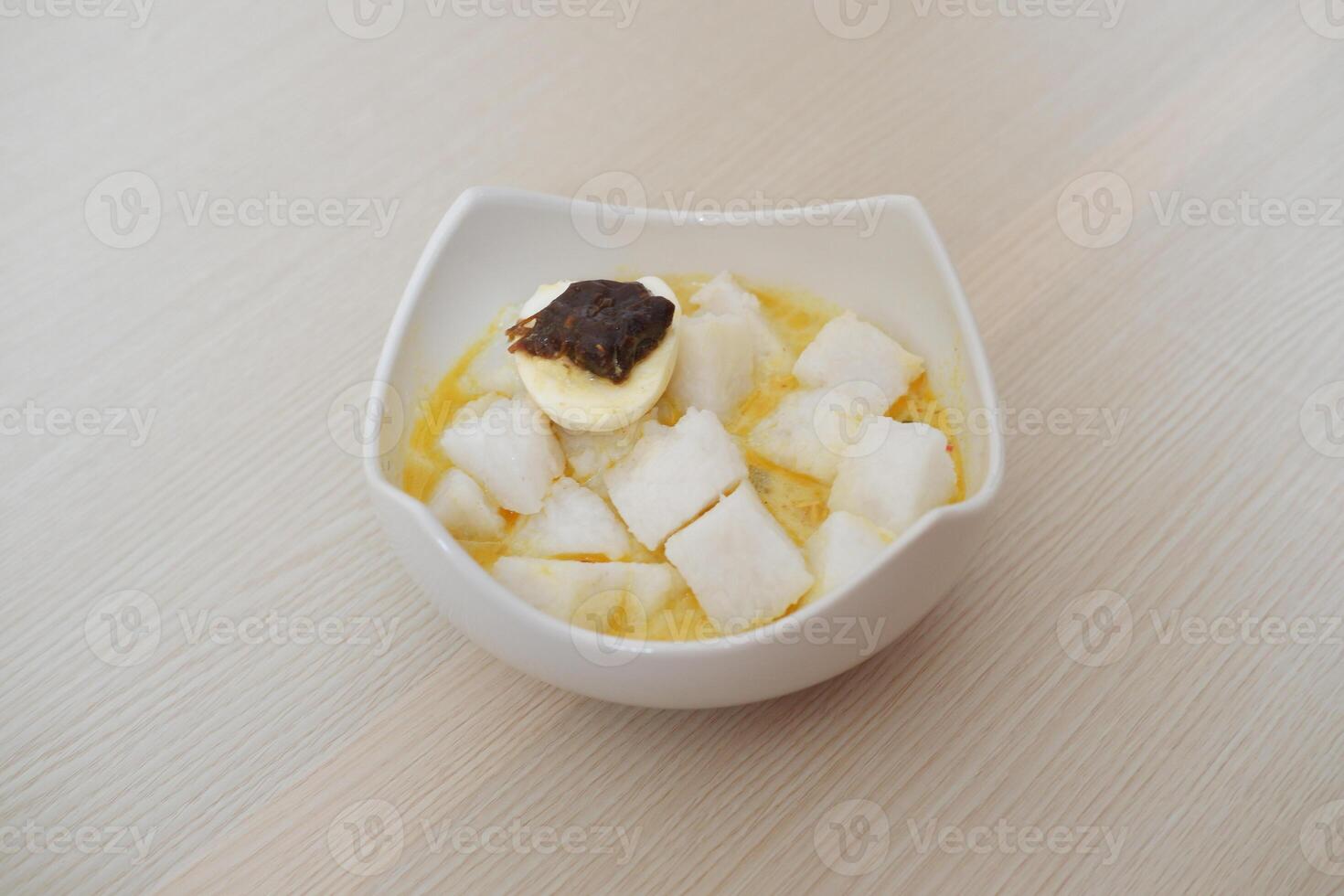lontong sayur- Compressed rice cake served with curry coconut milk sauce and vegetables and boiled egg photo