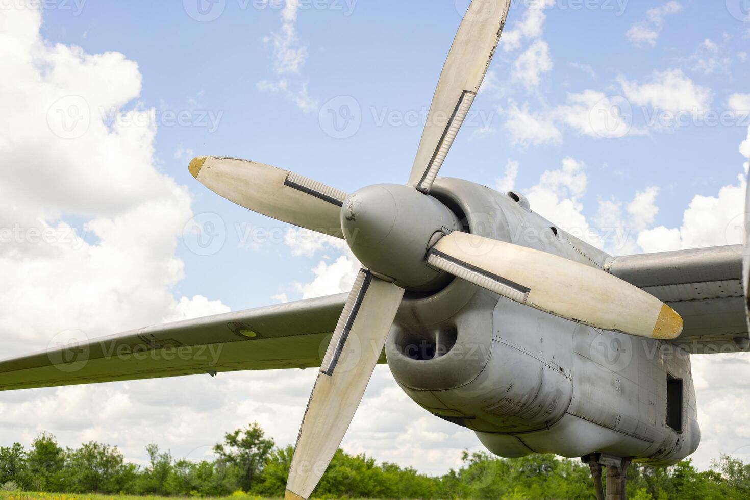 A fragment of airplane wing with four-bladed aircraft propeller against blue sky photo