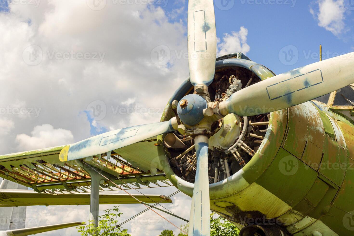 A fragment of airplane wing with four-bladed aircraft propeller against blue sky photo