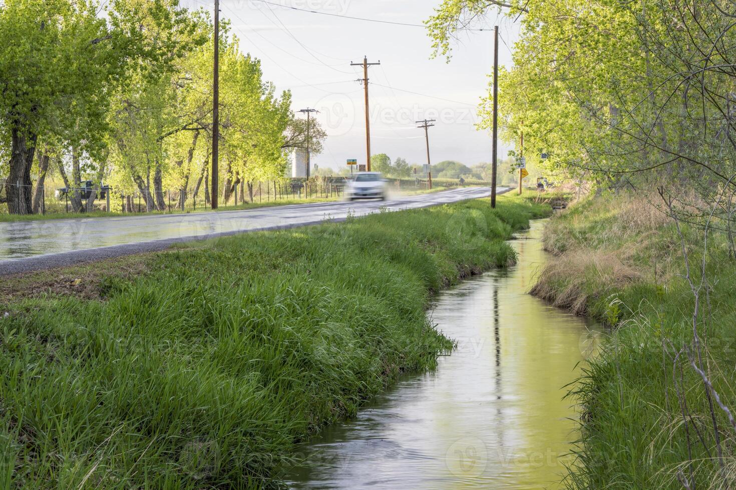 irrigation ditch and wet backcountry road in Colorado after springtime showers photo