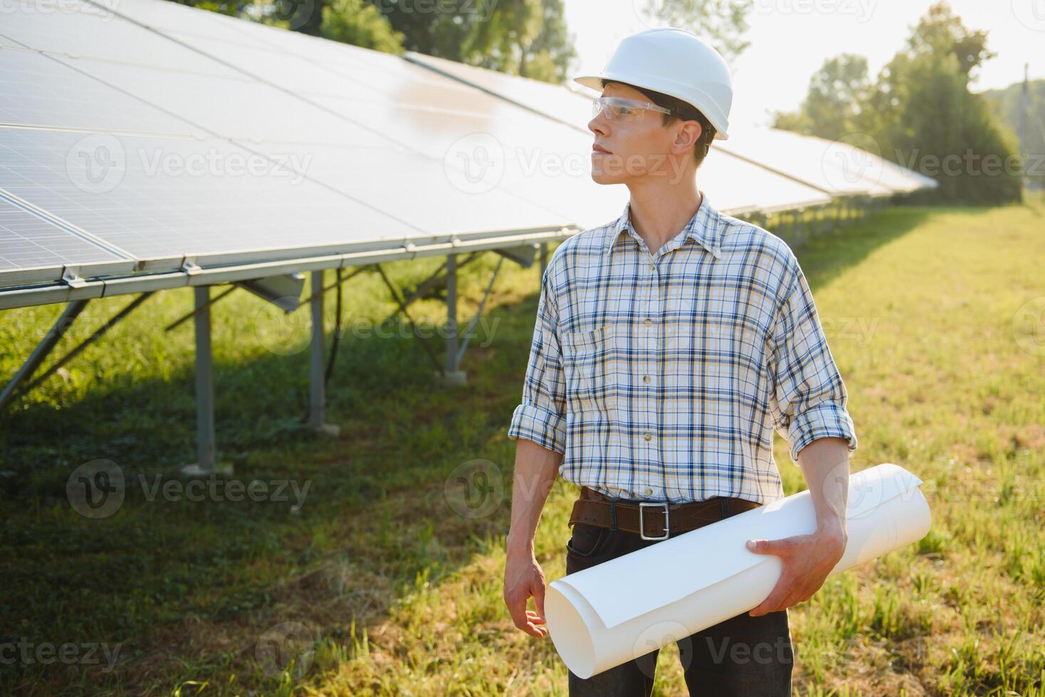 Installing and wiring of stand-alone solar photo voltaic panel system. Close-up of young electrician in hard-hat. Alternative energy concept.