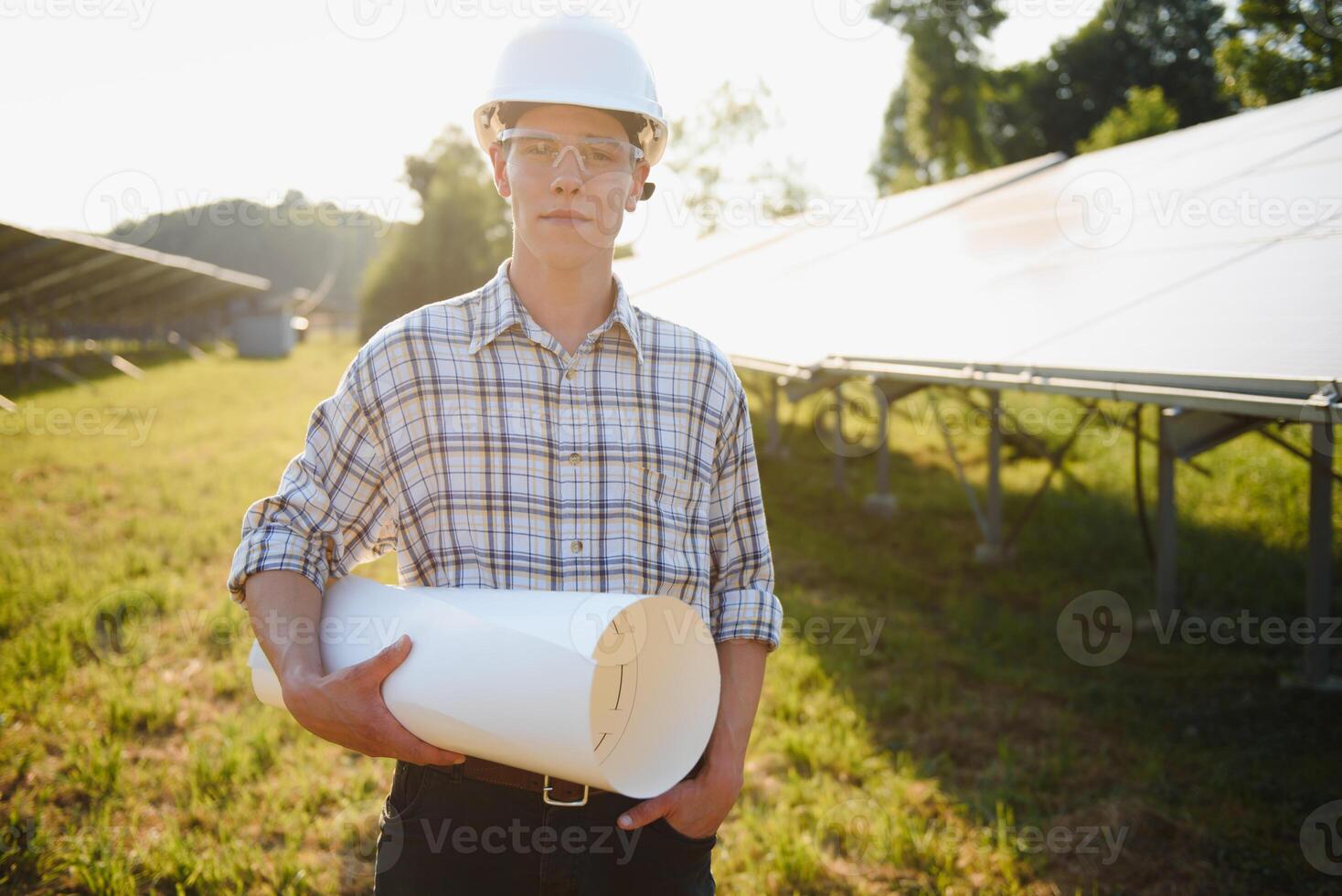 Installing and wiring of stand-alone solar photo voltaic panel system. Close-up of young electrician in hard-hat. Alternative energy concept.