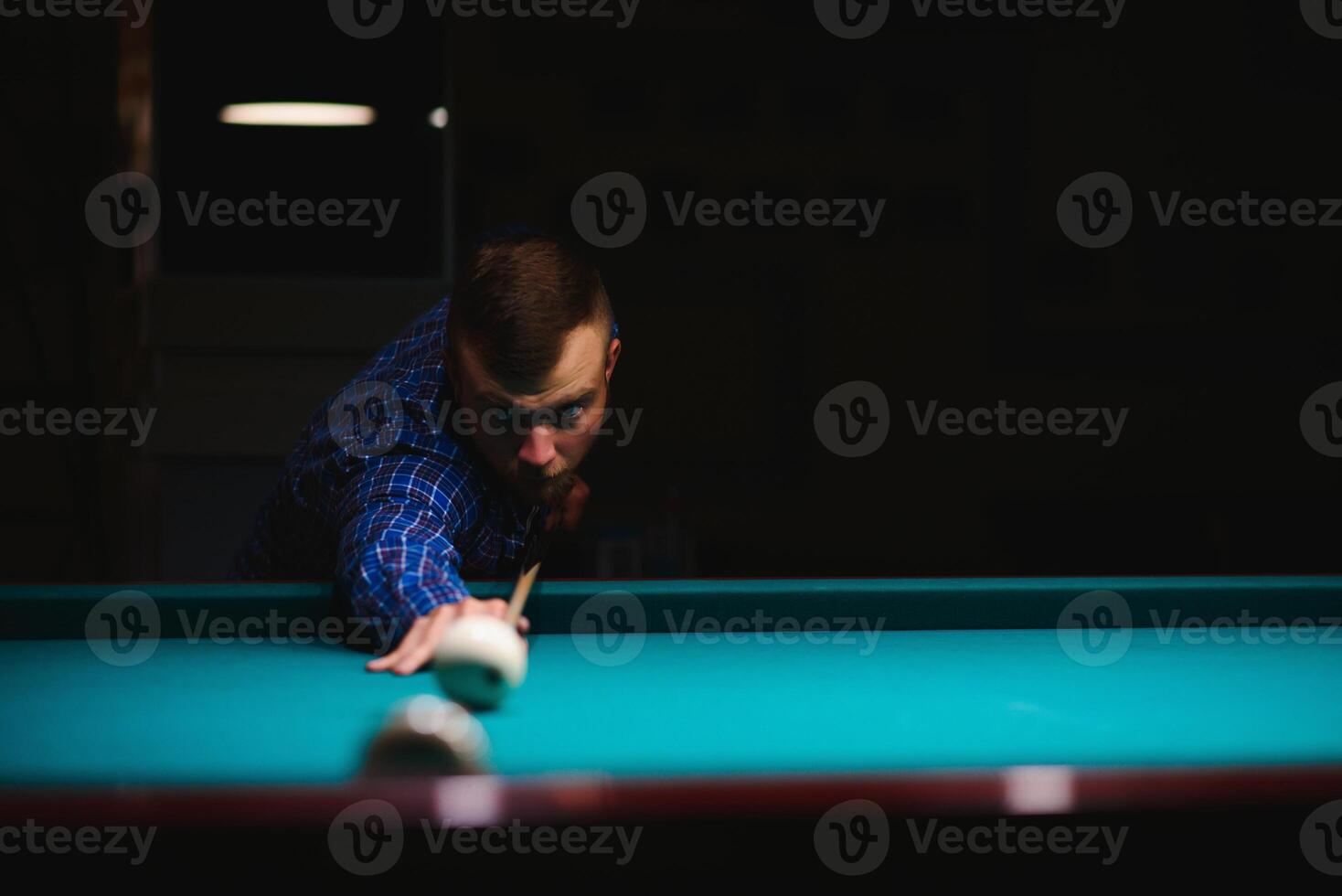 the player takes aim at the ball in Billiards photo